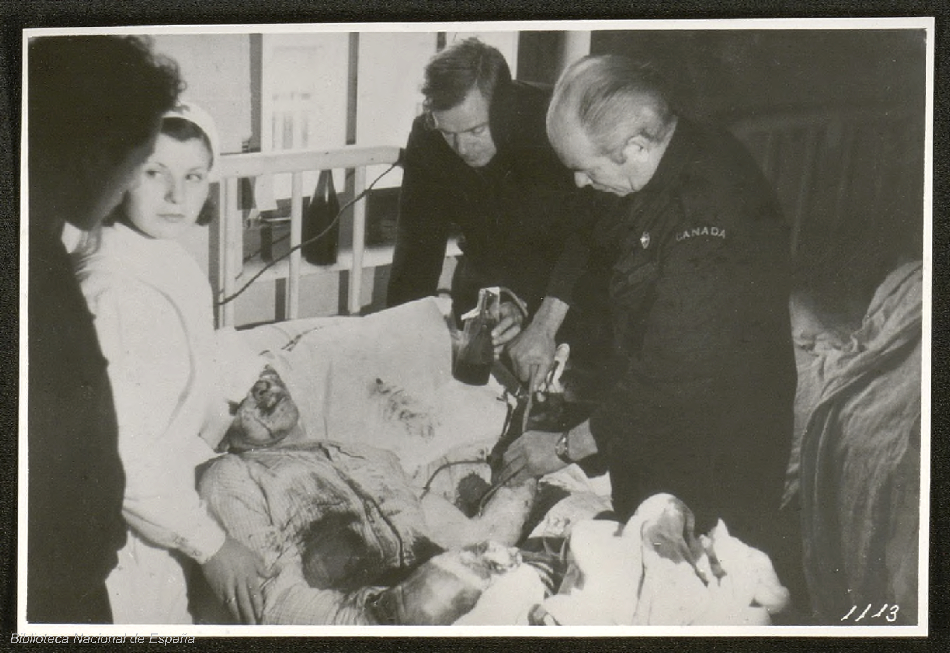 El doctor (derecha) hace una transfusi�n a un herido en la guerra civil.