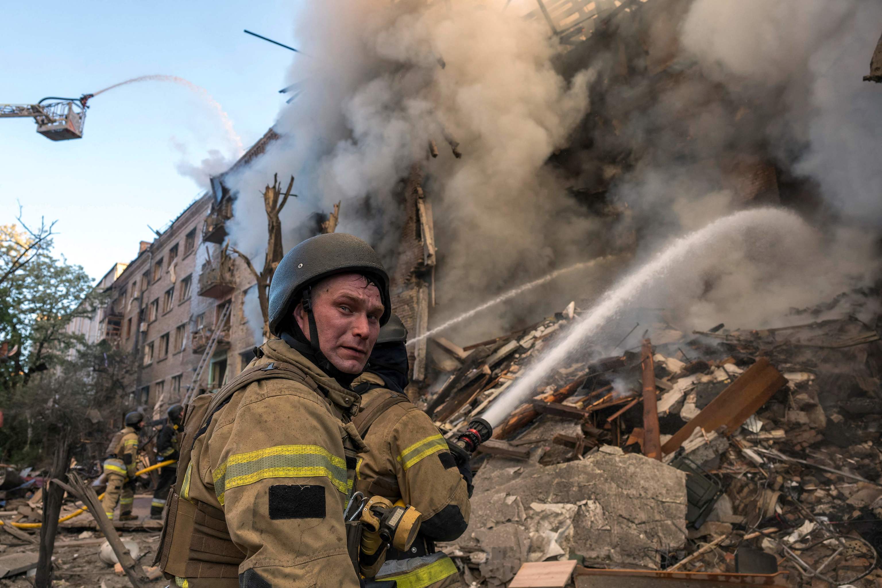 Bomberos apagan los incendios tras el bombardeo de Kiev.