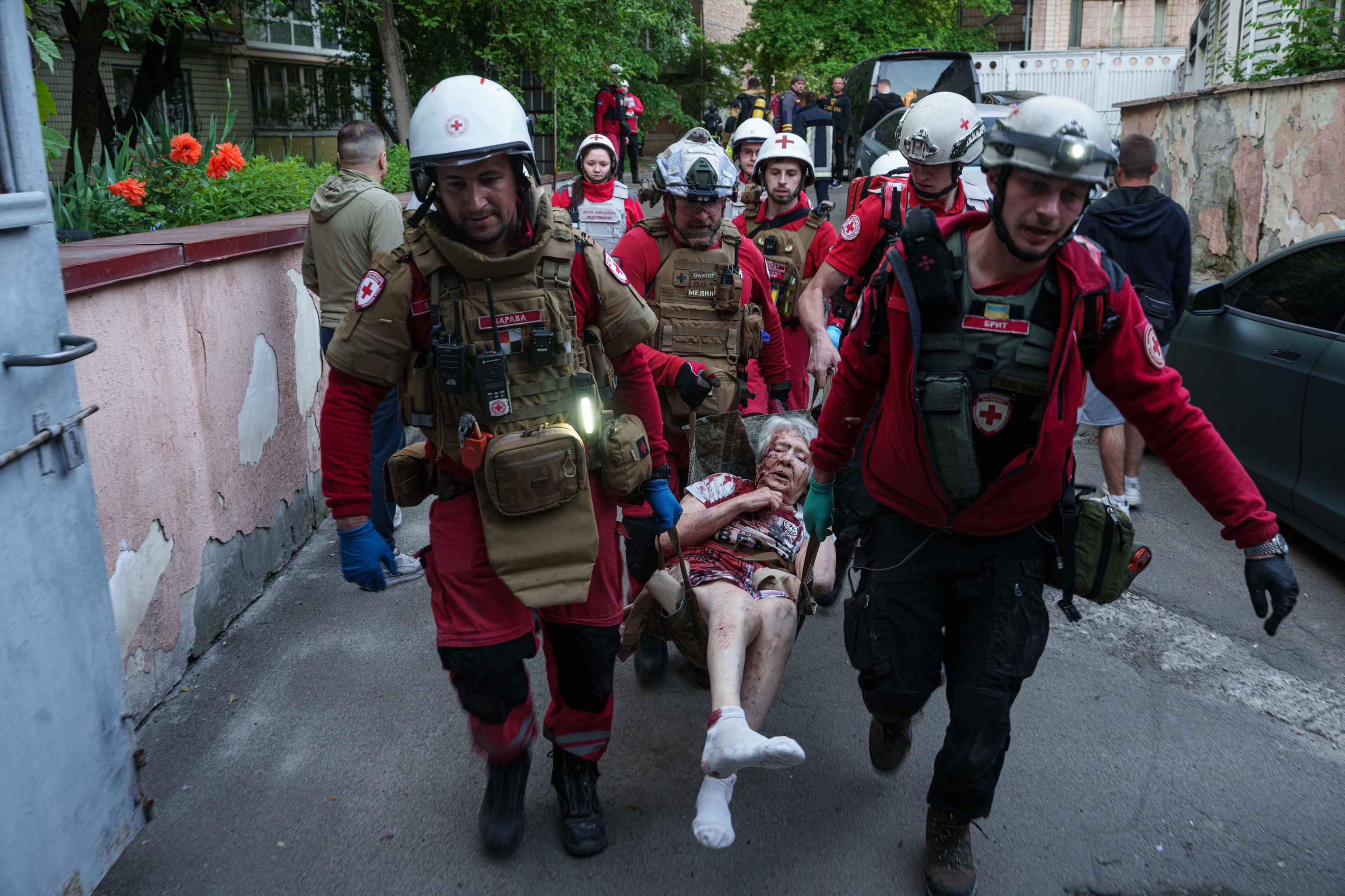 Voluntarios de Cruz Roja rescatan a una mujer de un edificio atacado.