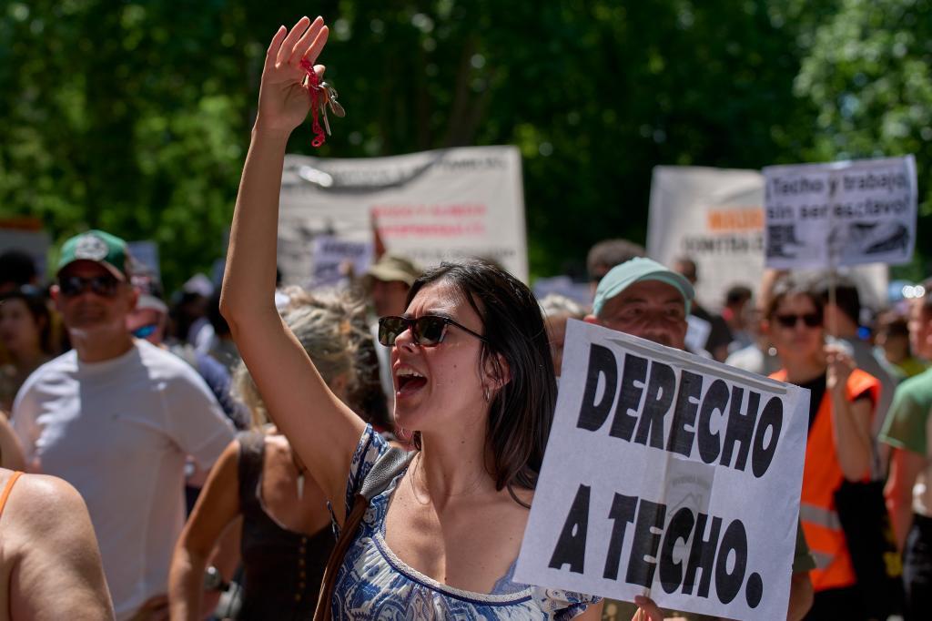 Una mujer sostiene una pancarta durante la protesta por la vivienda en Madrid