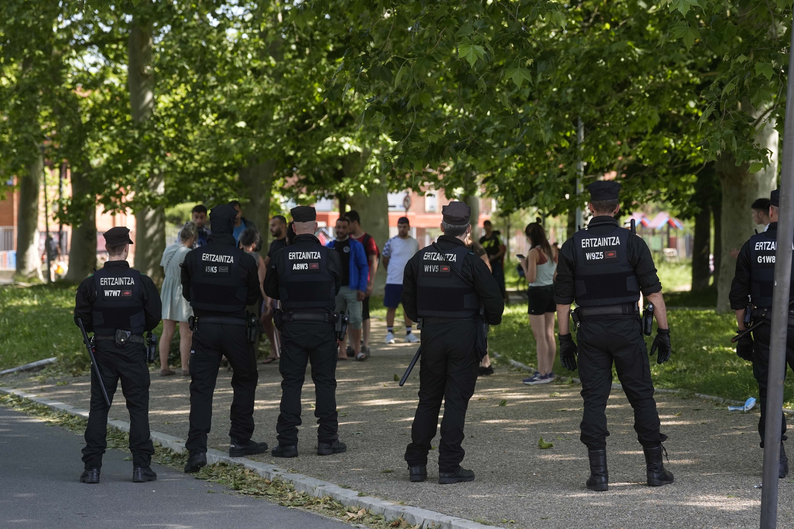 Varios ertzainas protegen el acceso a las fábricas 'okupadas' por migrantes magrebíes en el sur de Vitoria.