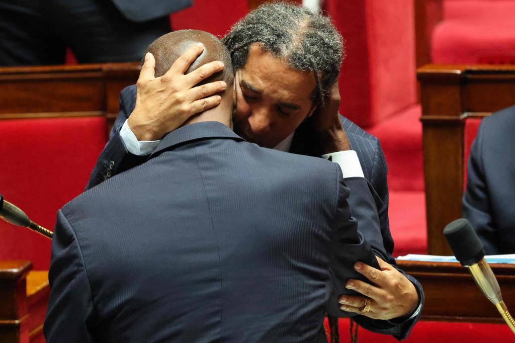 Dos diputados se abrazan en la Asamblea gala tras la derogación del 'Código Negro'.