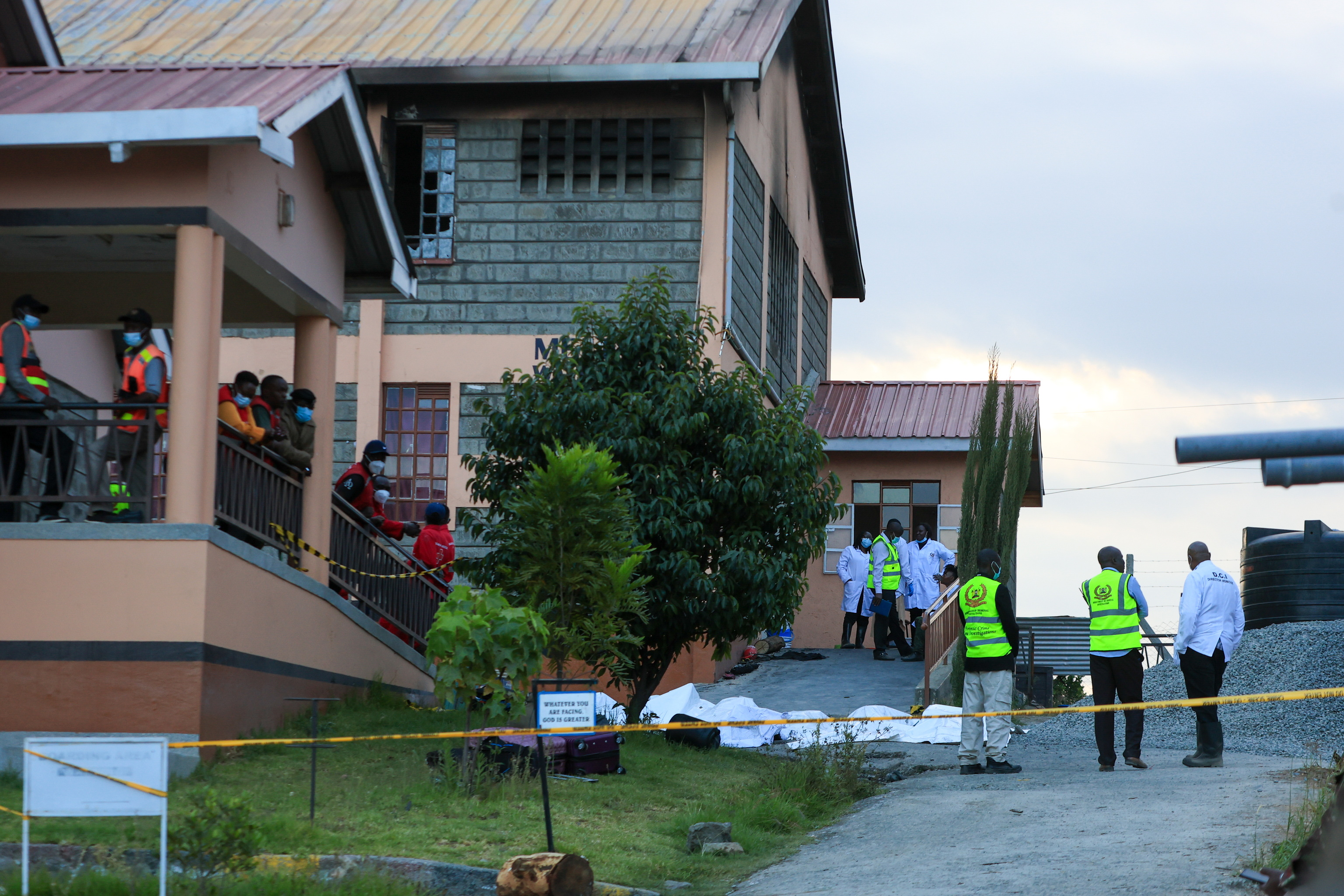 Varios cuerpos de ni�as fallecidas en el exterior de la escuela incendiada.