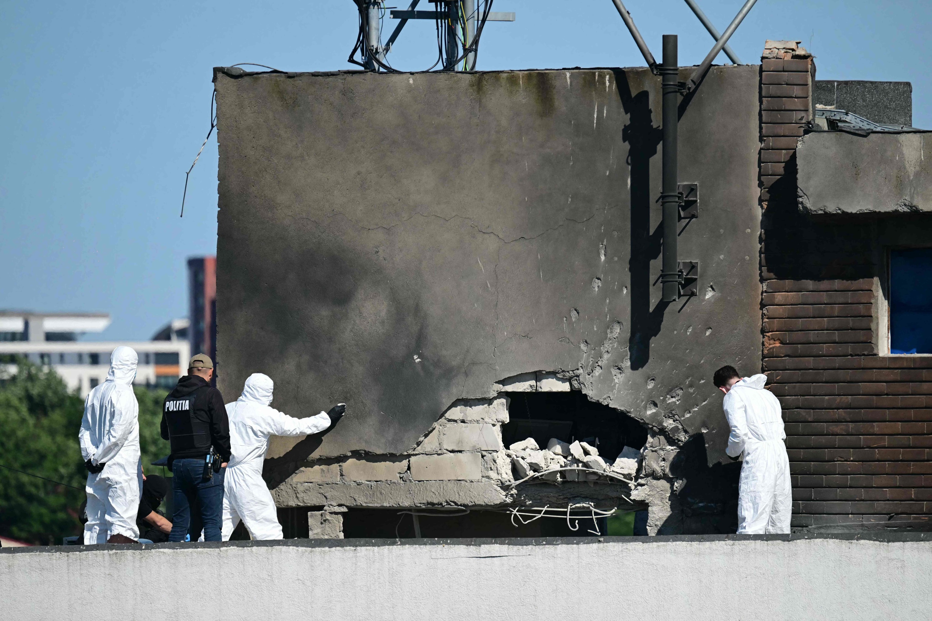 Investigadores forenses examinan el lugar del impacto tras el choque de un dron ruso contra un edificio de apartamentos en Galati, al oeste de Rumanía.