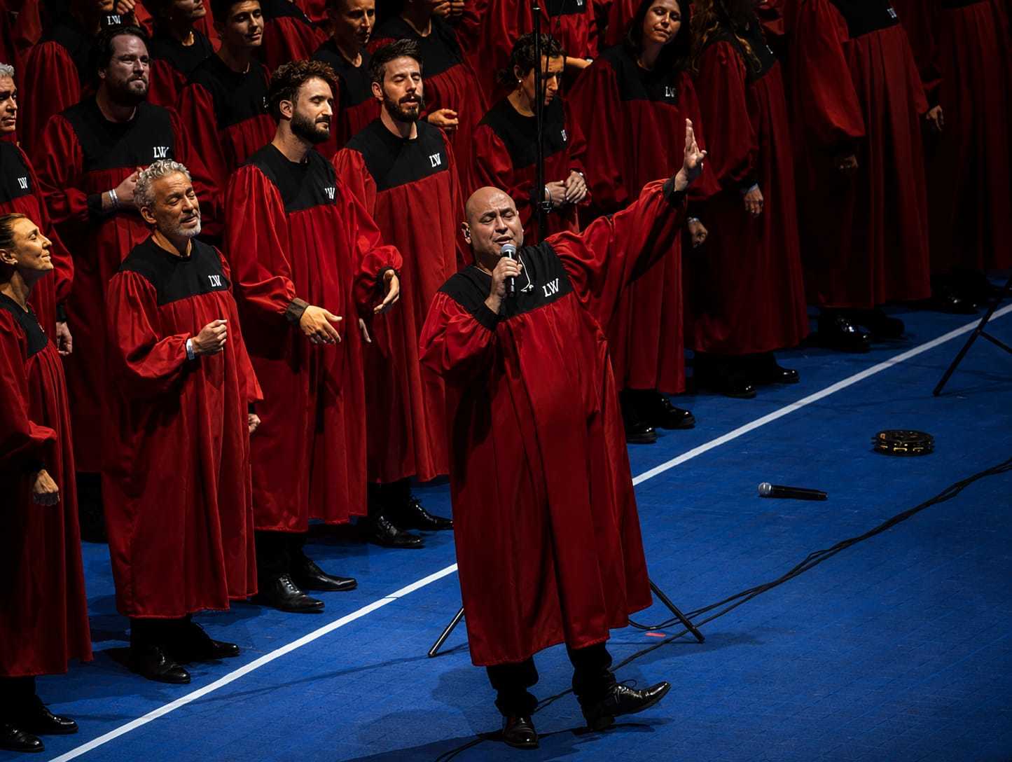 Un coro gospel con túnicas rojas y negras actúa de teleneros.