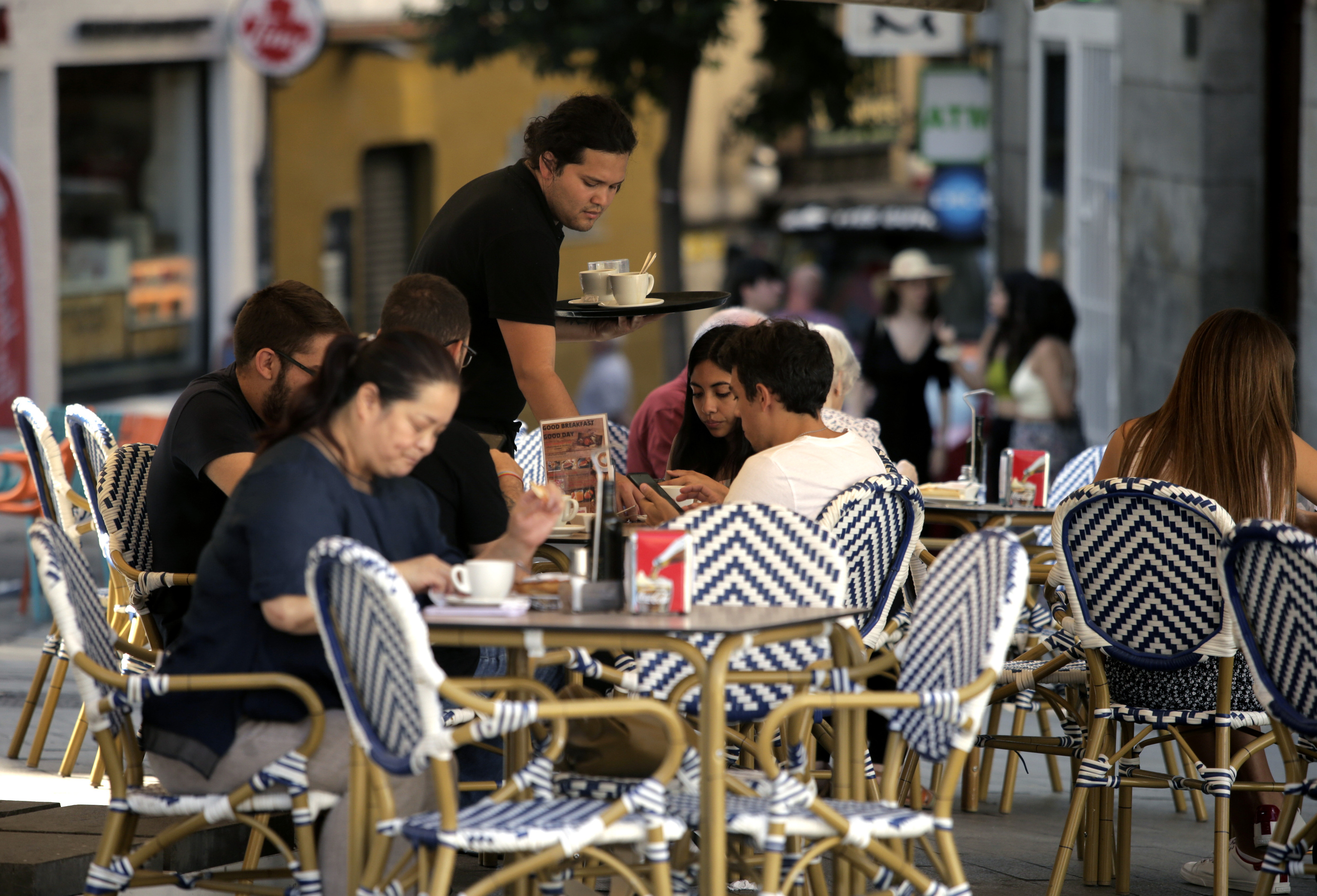 Un camarero atiende una mesa en una terraza del centro de Madrid.