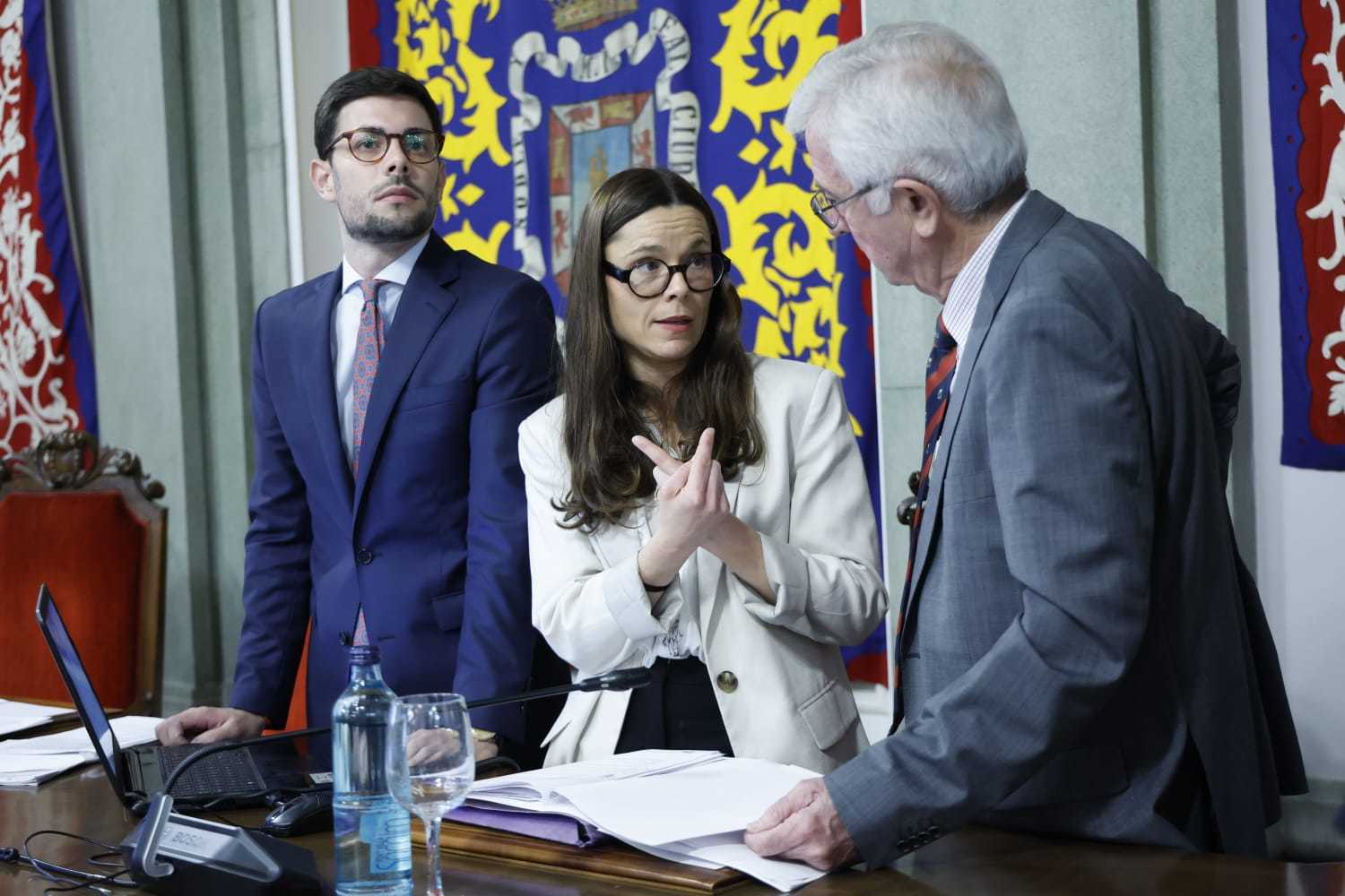 La secretaria municipal (centro) discute con el presidente de la Mesa de Edad, Enrique Pérez Abellán (izq), en el Salón de Plenos del Ayuntamiento de Cartagena