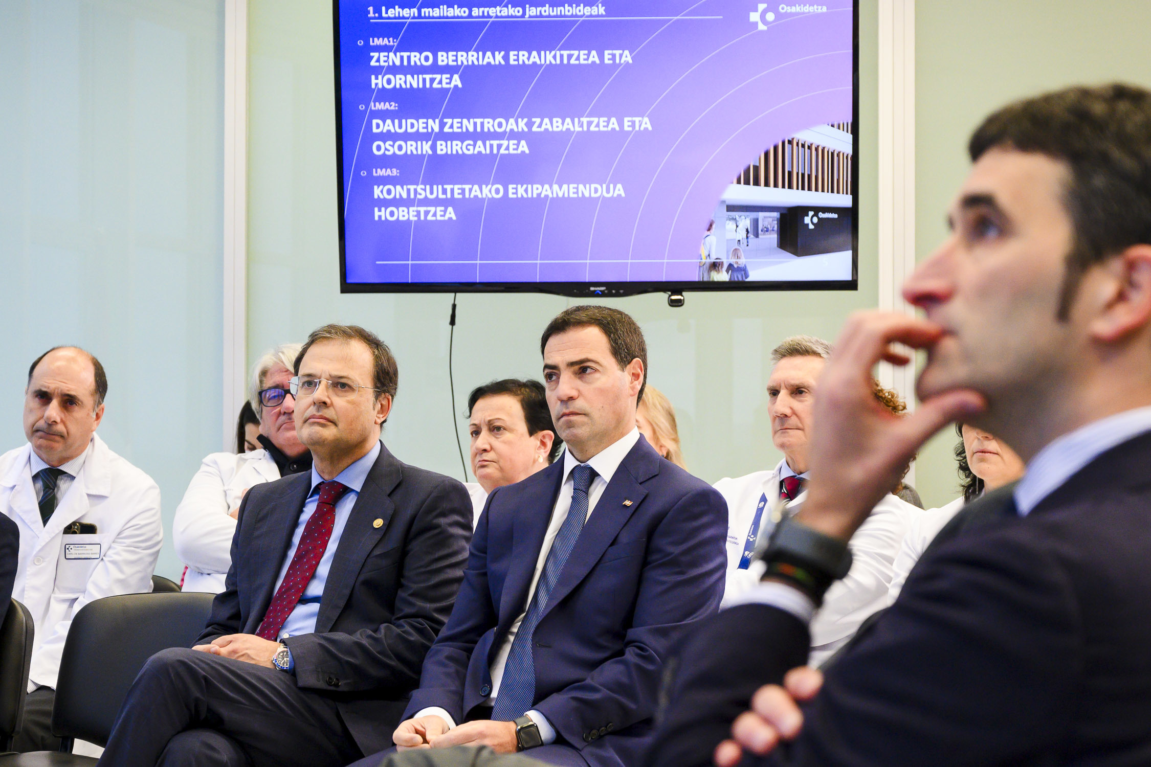 El consejero Alberto Martínez y el lehendakari Pradales rodeados de directivos de Osakidetza en un encuentro para explicar el plan de inversiones en infraestructuras sanitarias.