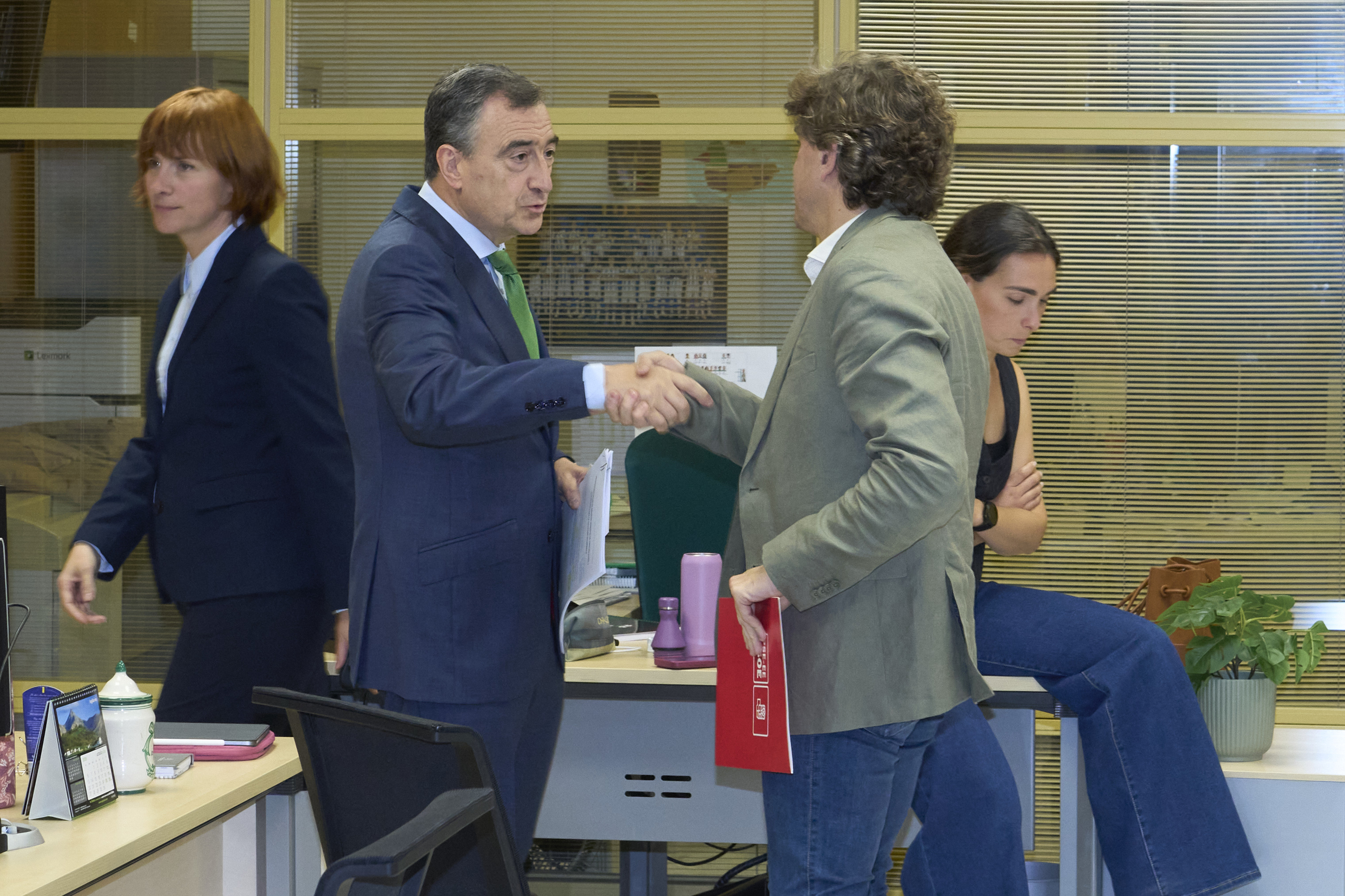 El presidente del PNV Aitor Esteban estrecha la mano del socialista Eneko Andueza antes de comparecer juntos en el Parlamento Vasco.