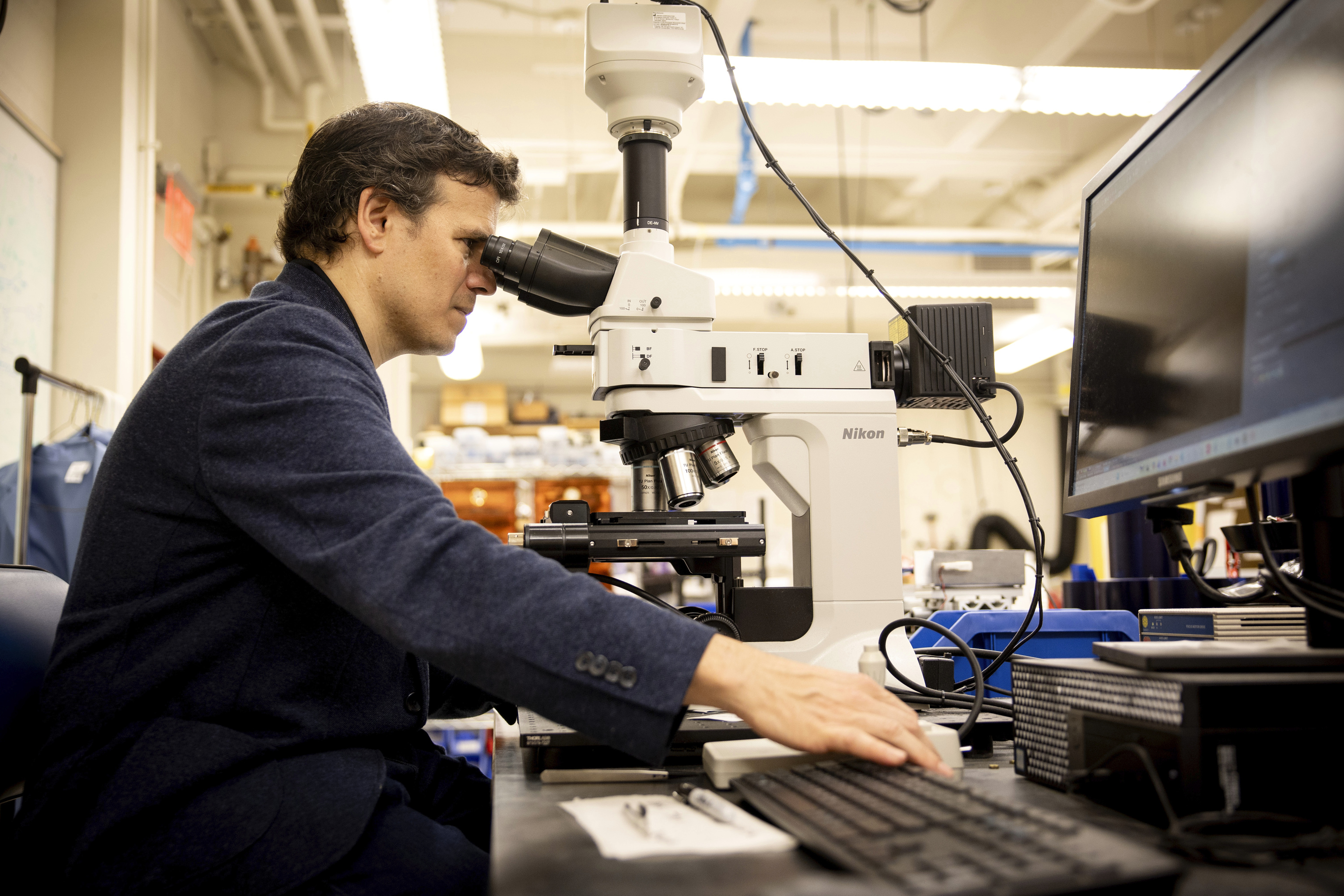 El científico examina una muestra de grafeno al microscopio.