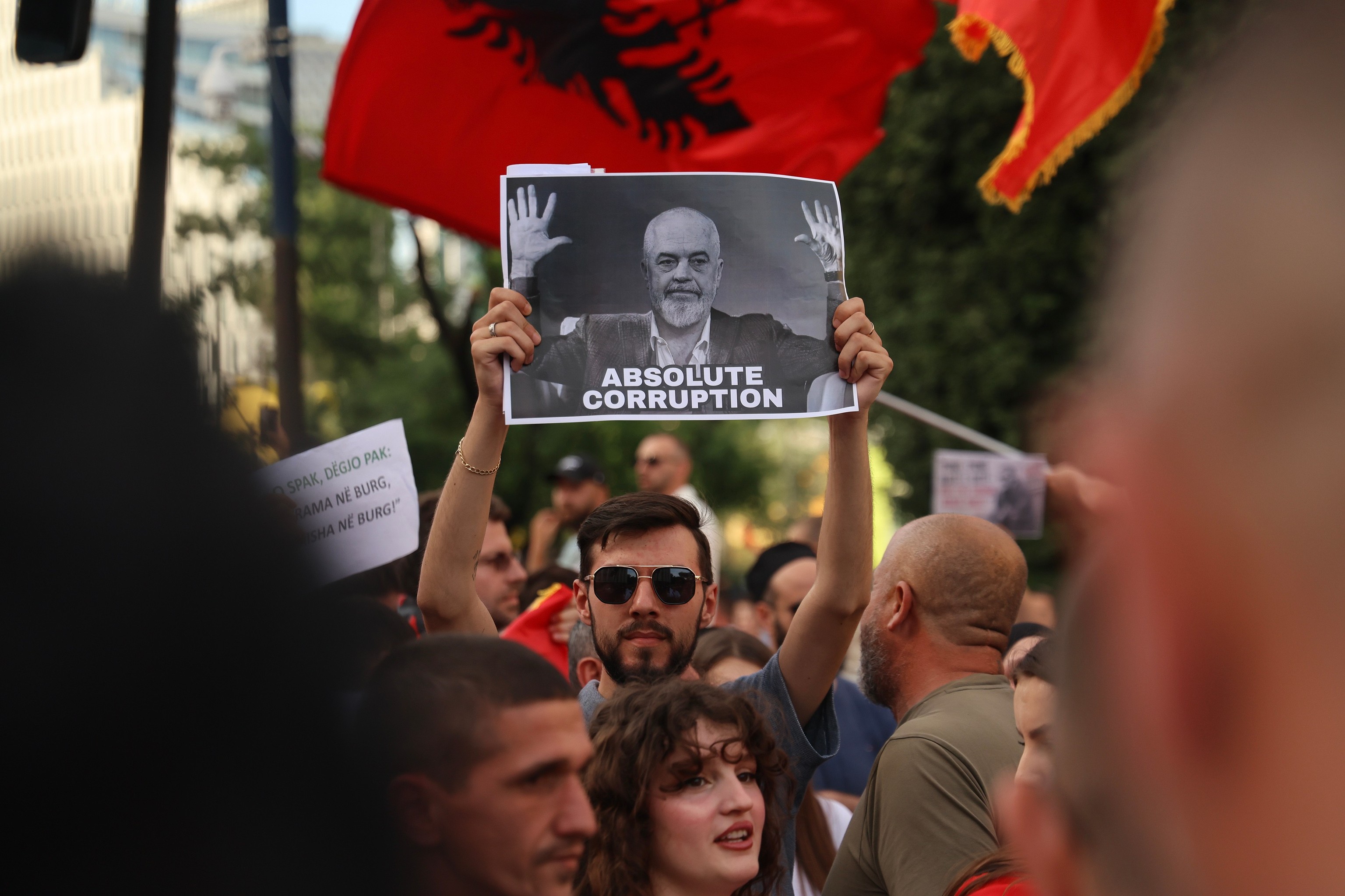 Manifestantes, con una pancarta en la que aparece el primer ministro Edi Rama, en Tirana.