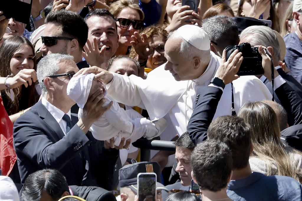 El papa León XIV bendice a un bebé a su llegada a la Abadía de Nuestra Señora de Montserrat