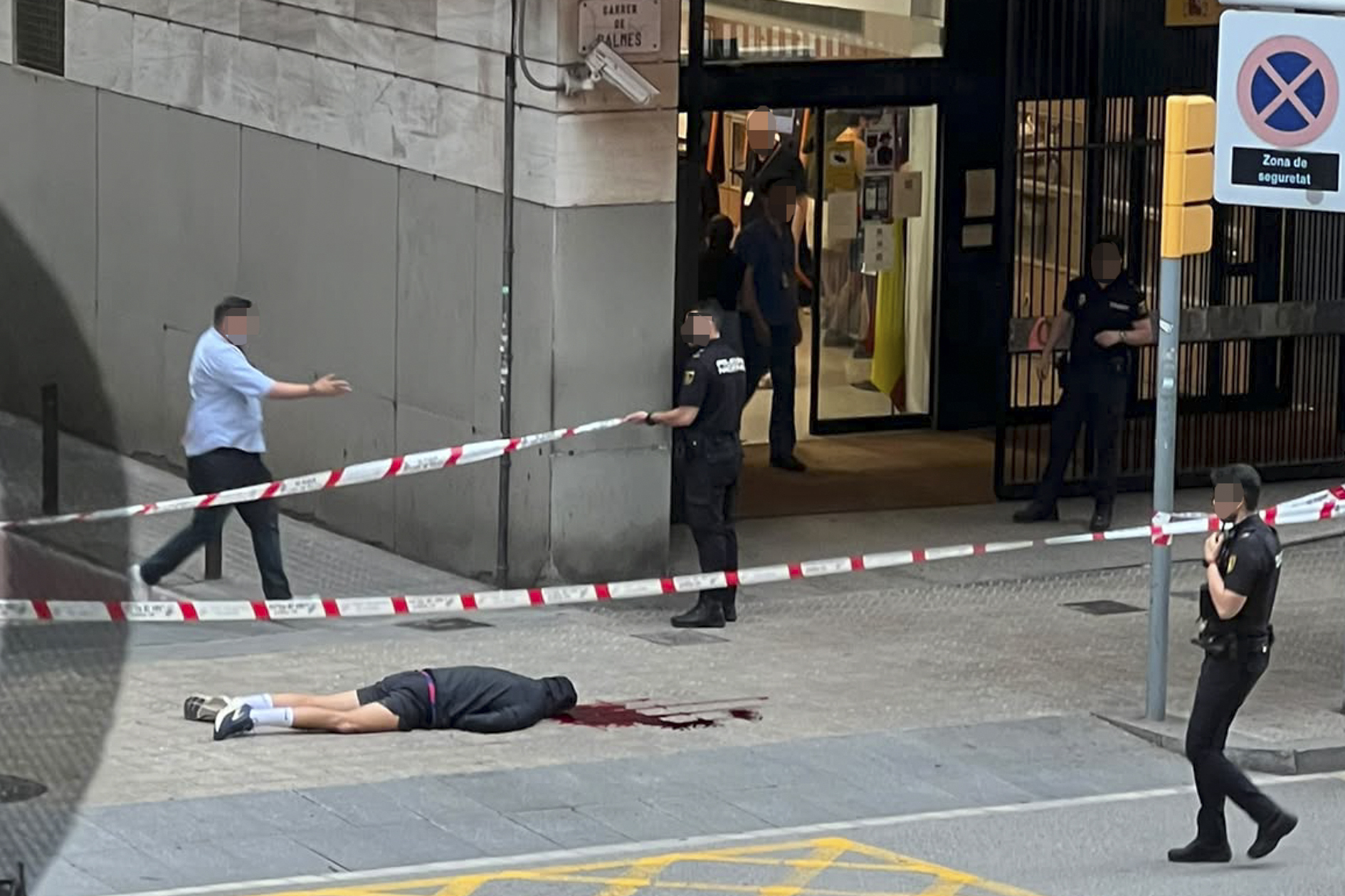La víctima del asesinato registrado ayer en Barcelona yace tendida en el lugar del homicidio, en la calle Balmes.