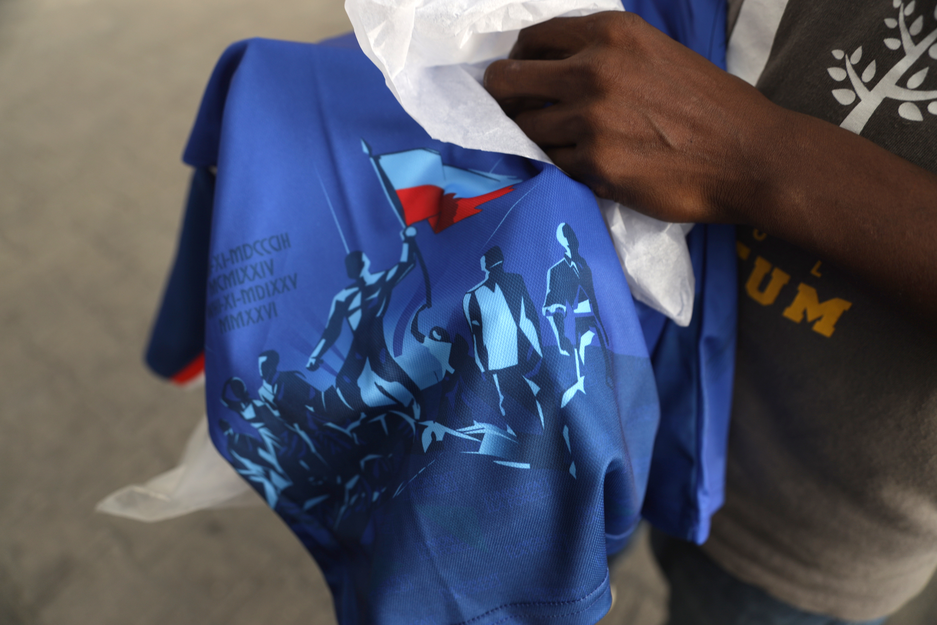 Una persona sostiene una camiseta de Haití que la FIFA consideró que infringía sus normas.
