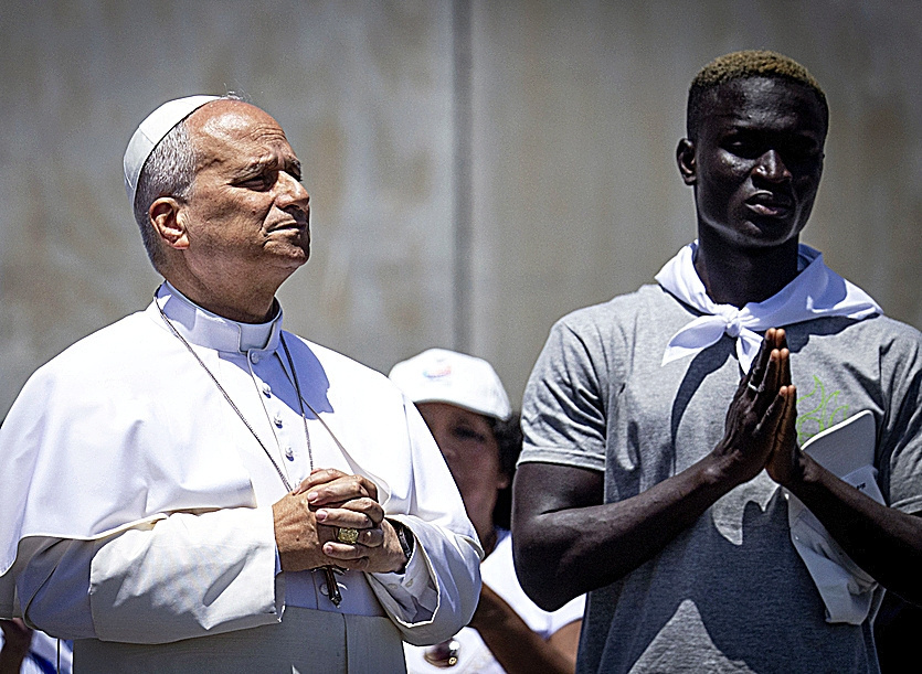 León XIV reza junto a otro de los inmigrantes en el muelle de la Esperanza.
