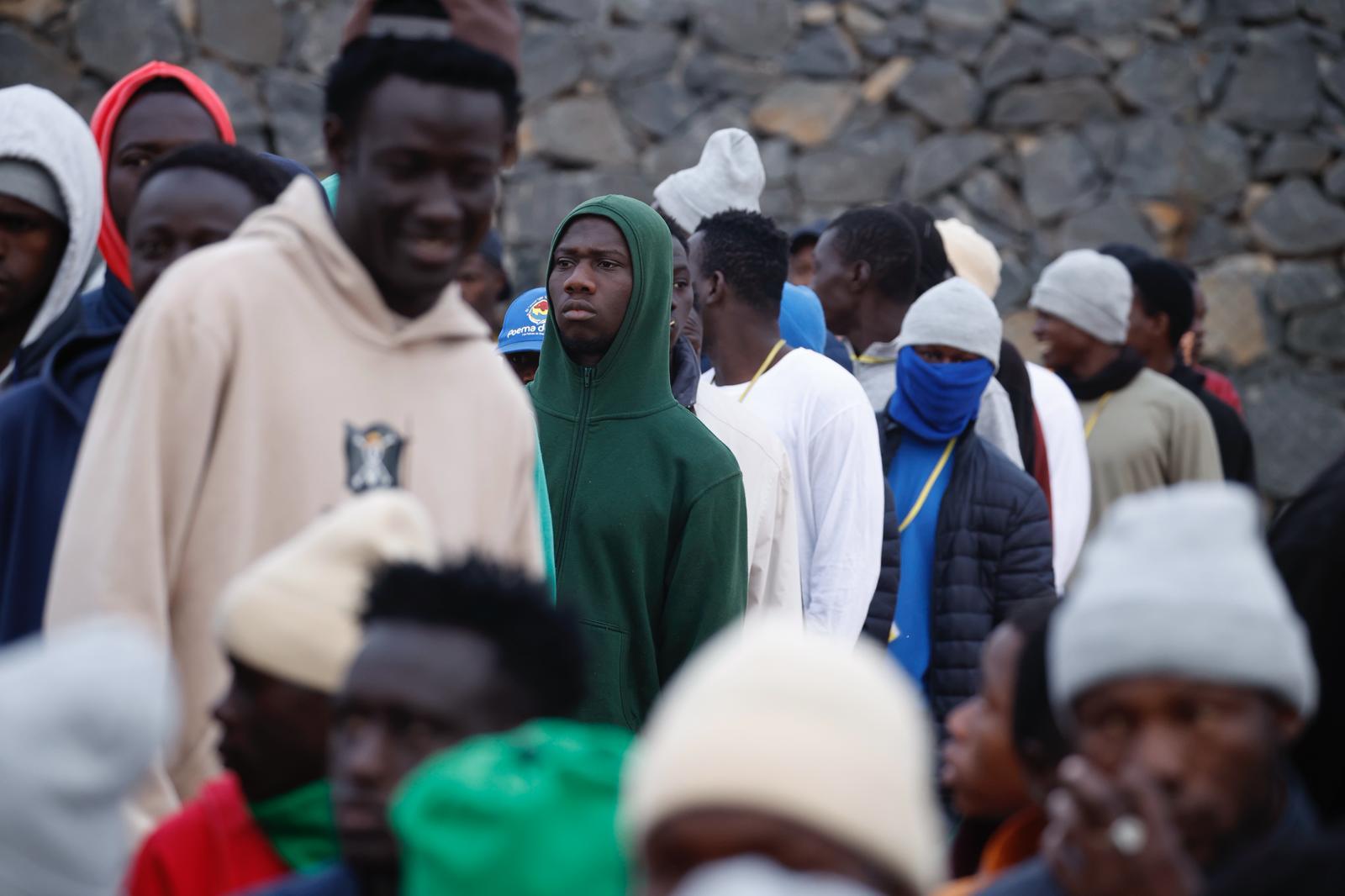 Varios migrantes esperan la llegada del pontífice en la explanada.