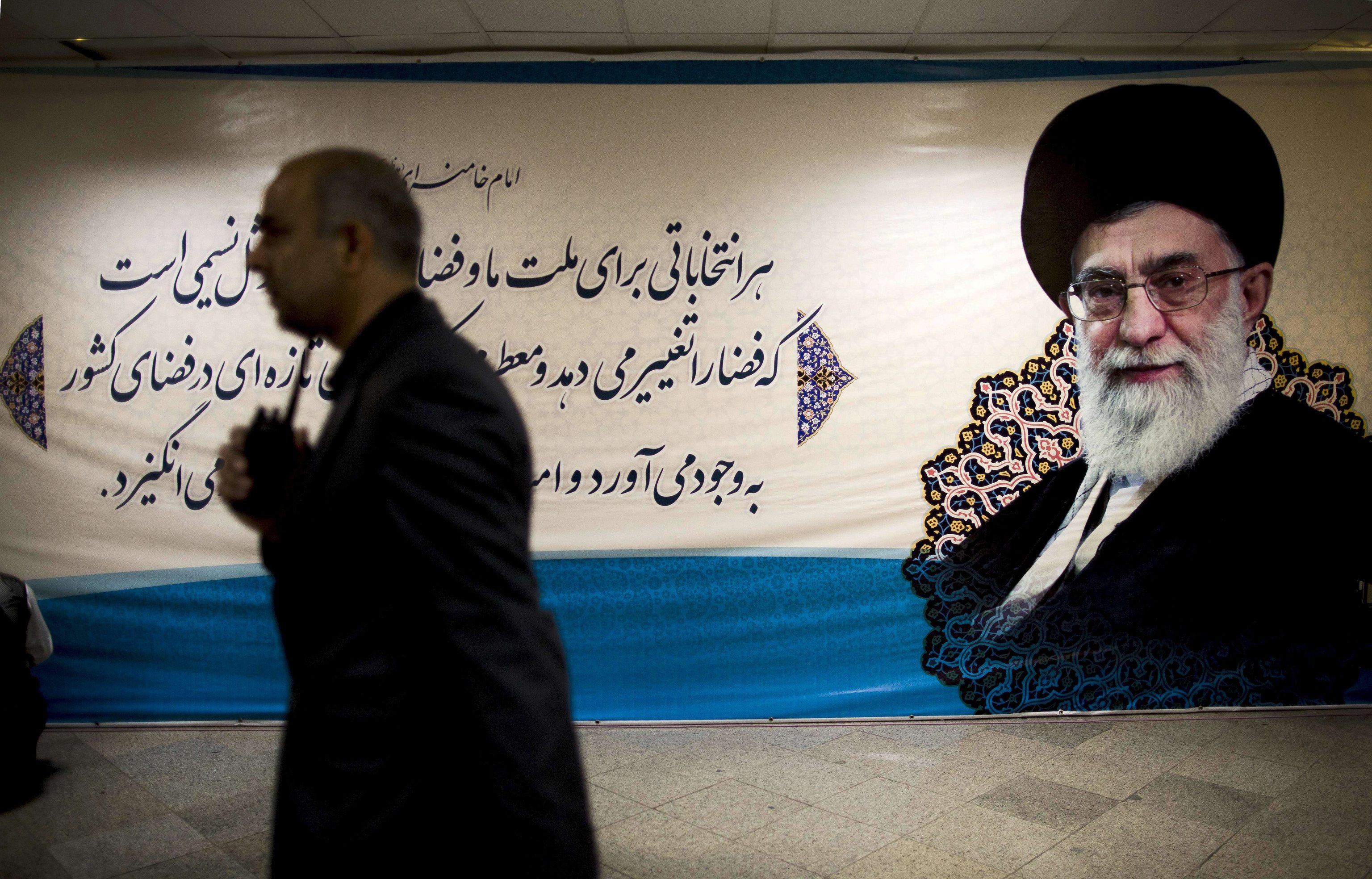 Un hombre camina por delante de un cartel en Teherán del fallecido líder iranía Ali Jamenei.