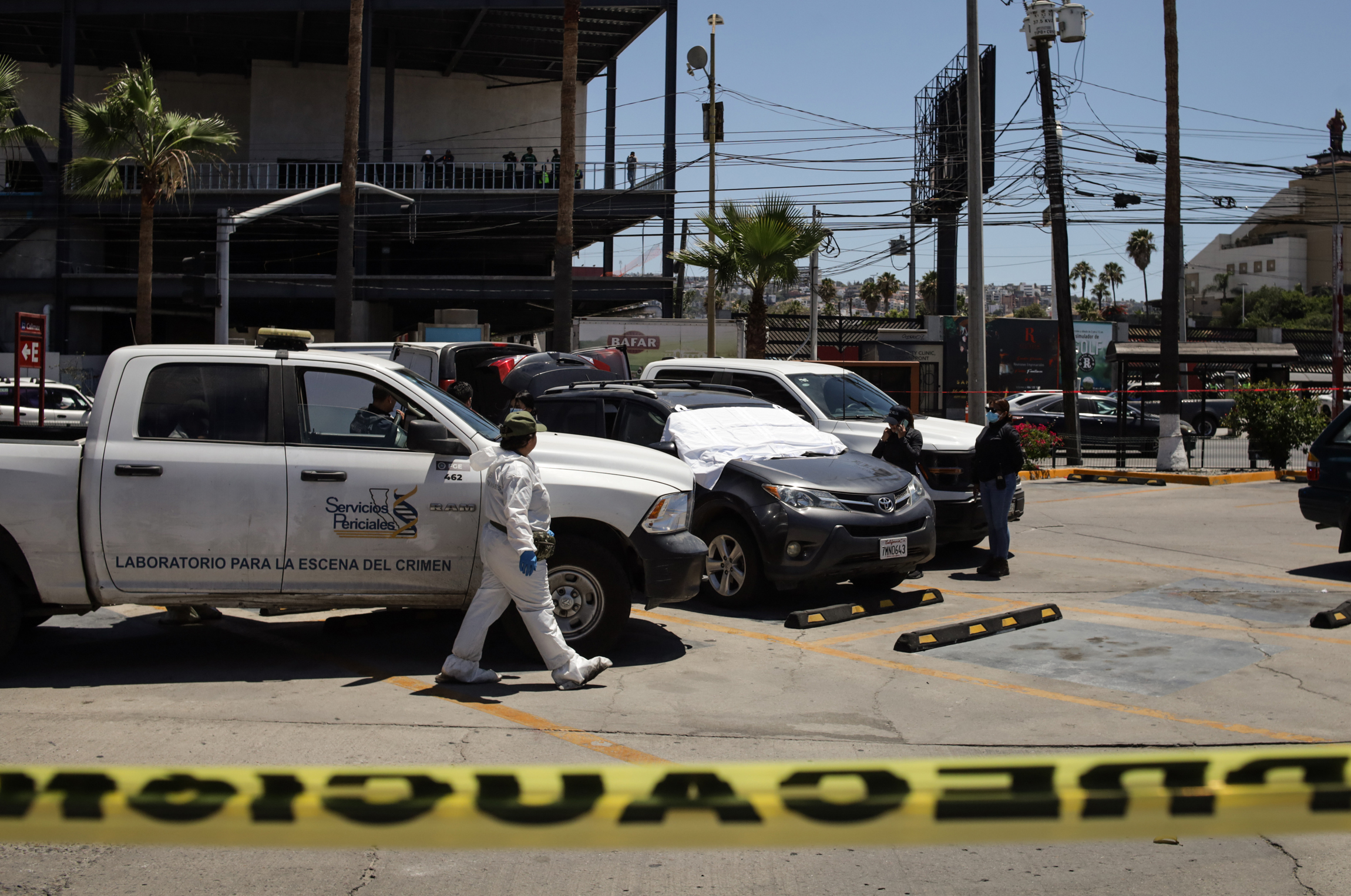 Integrantes de la Policía de México custodian la zona de un crimen este sábado, en Tijuana (méxico).