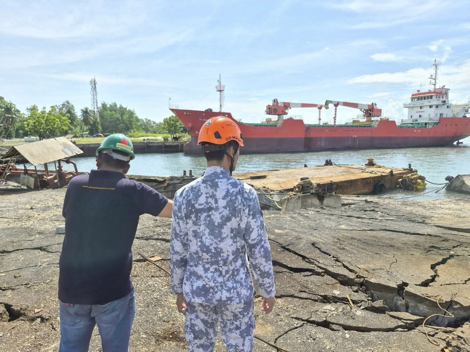 Operarios filipinos observan los daños producidos en el puerto de Sarangani.