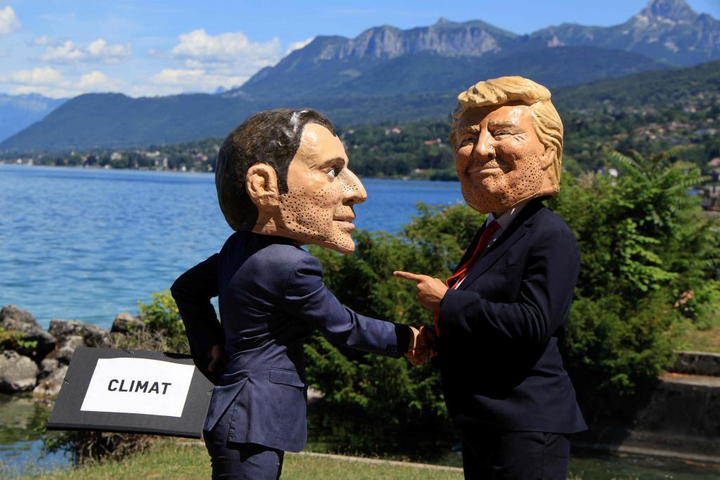 Manifestantes disfrazados con caricaturas de cabezas gigantes que representan a Macron y Trump, ante la cumbre del G7.