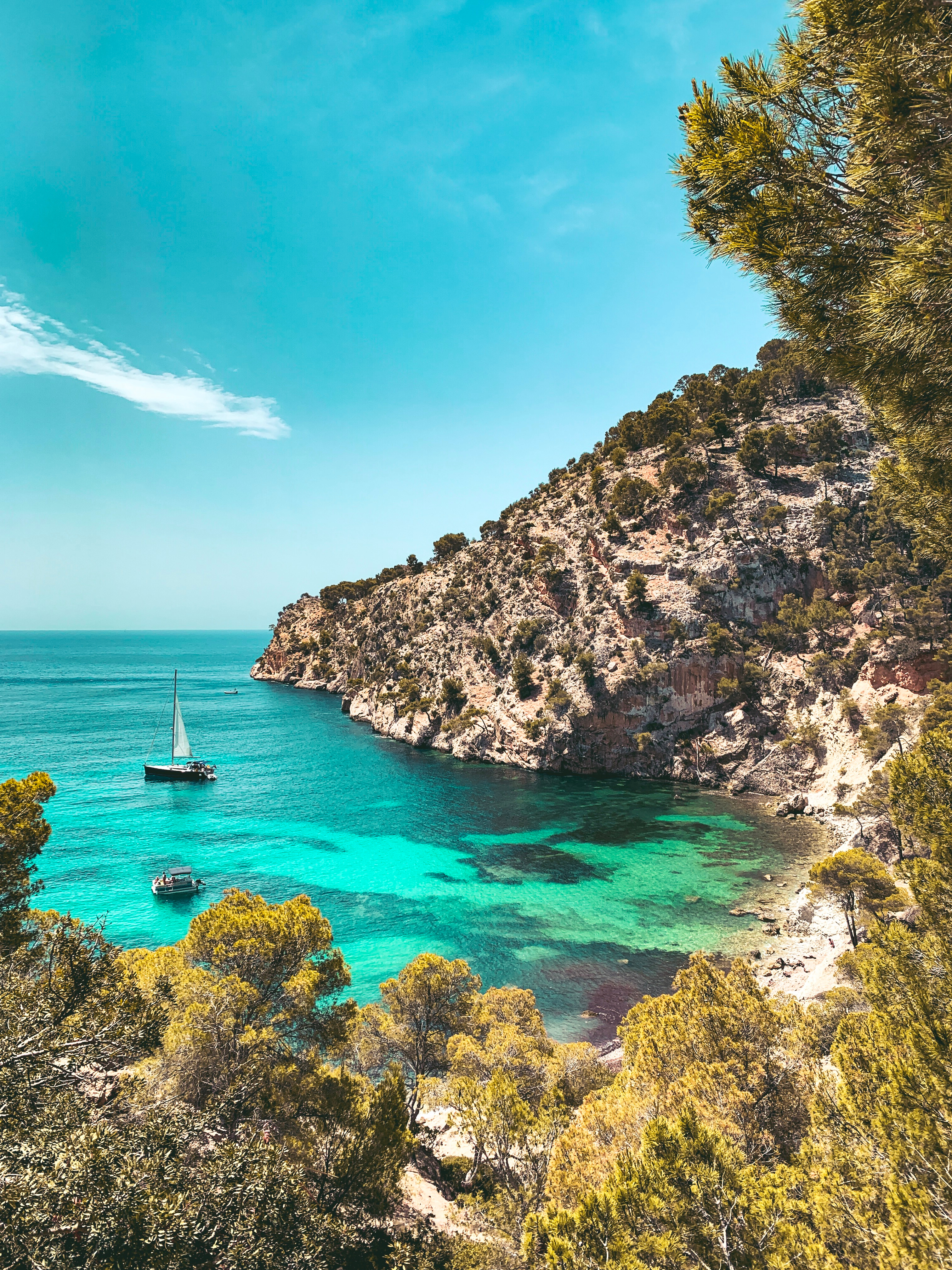 Un par de barcos fondean en Cala Blanca.