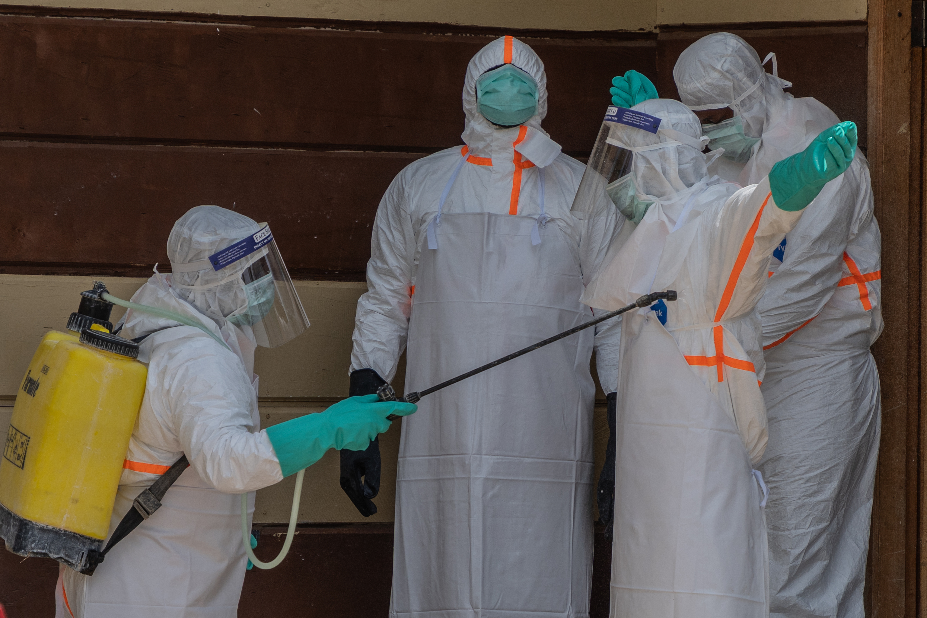 Trabajadores de salud se desinfectan tras preparar el cuerpo de una víctima de ébola en la clínica Citadelle en Buni (Congo).a