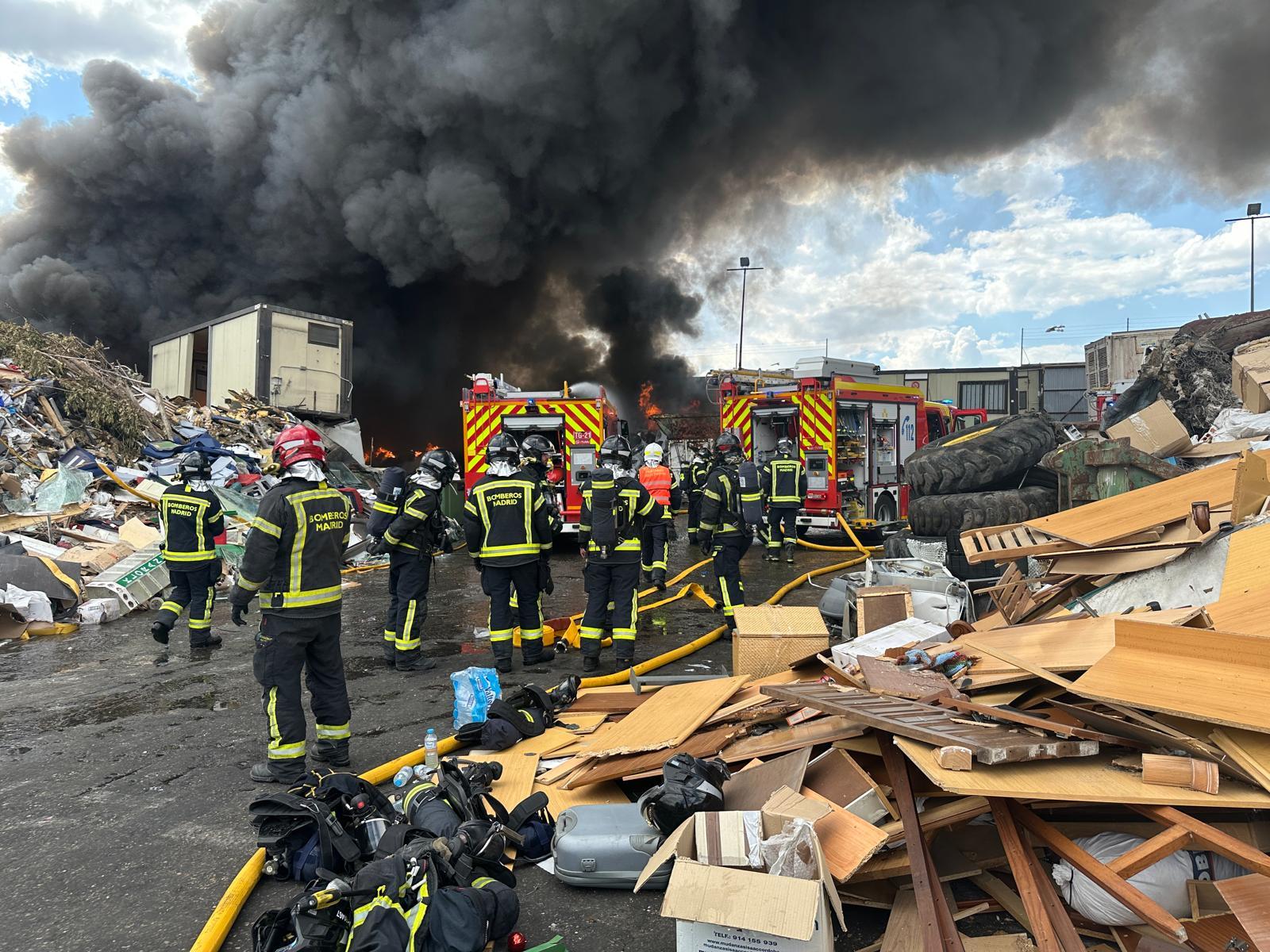 Los bomberos en la chatarrería incendiada.