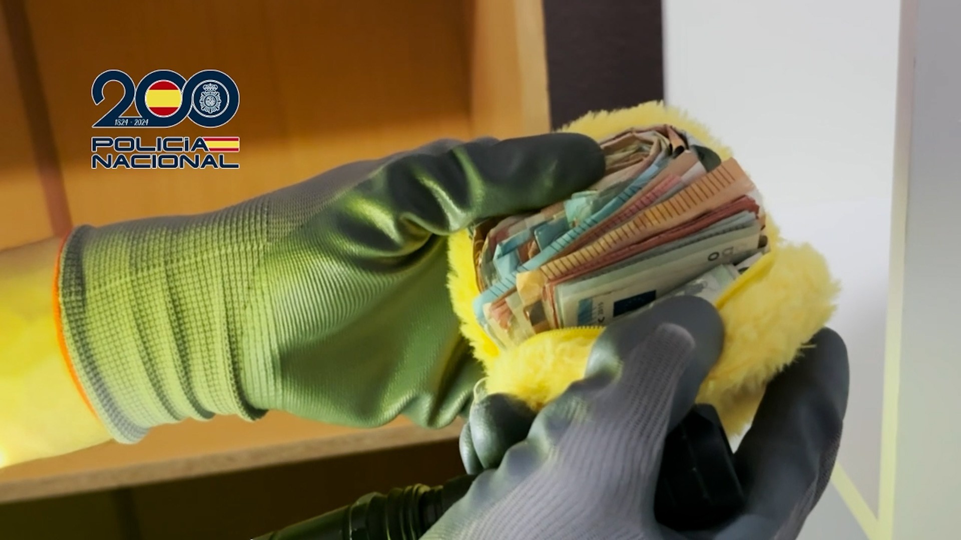 Un agentes con dinero incautado a los detenidos.