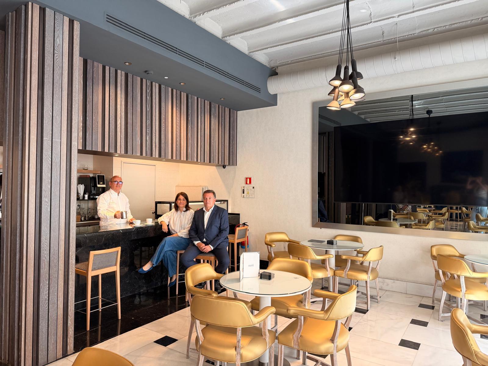 La propietaria y el director del hotel, junto a Joaquín Ardura, en la cafetería del hotel antes de ser 'redecorada'.