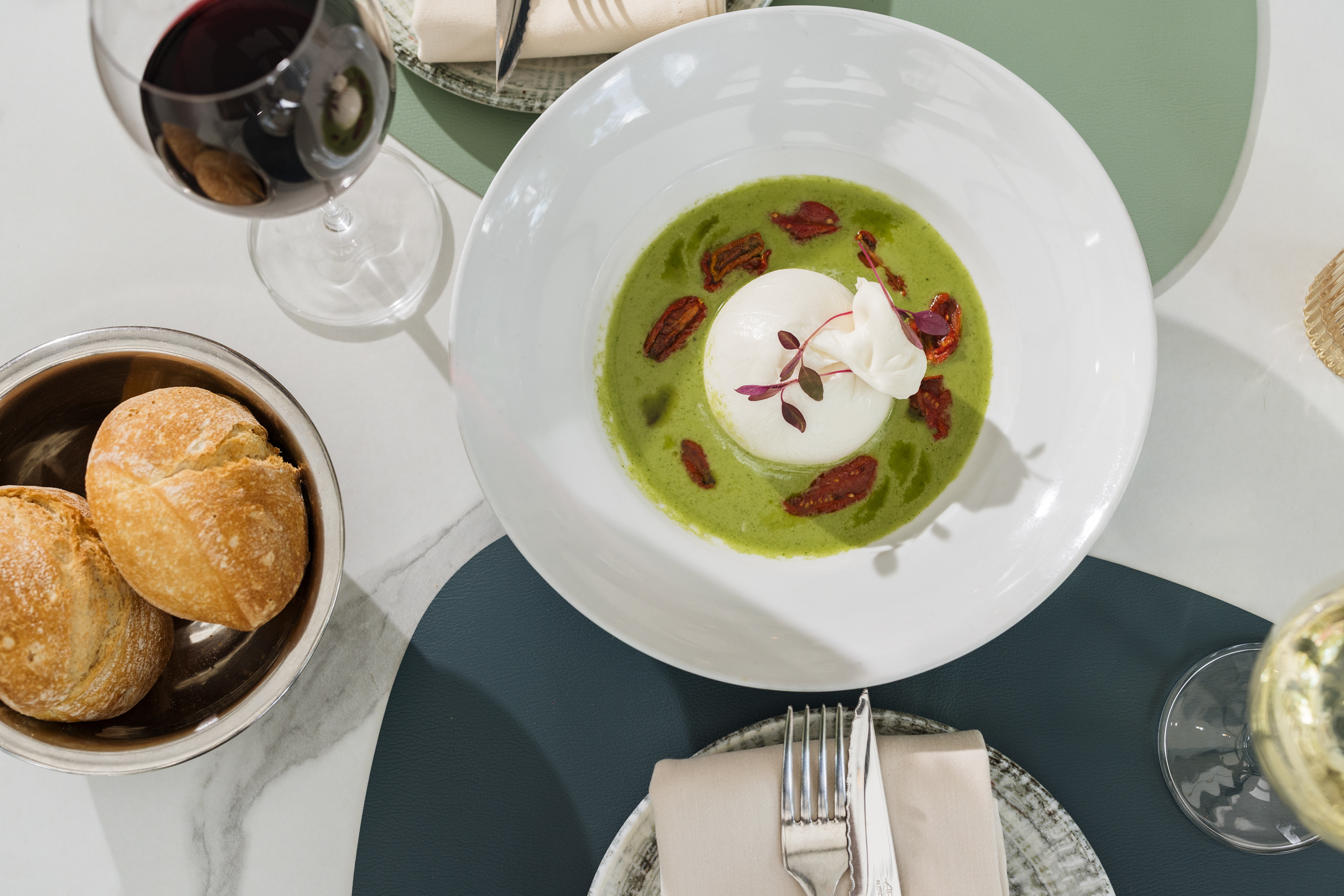 Burrata italiana, con gazpacho verde, tomates cherry semisecos y amaranto rojo de Café Mies.