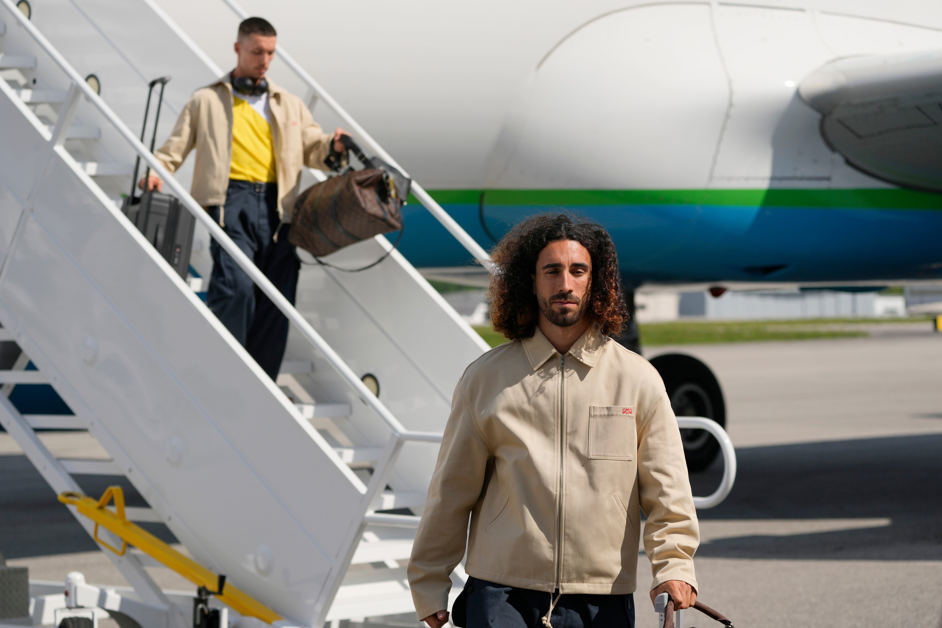 Cucurella desciende del avión de la selección vestido de Loewe.
