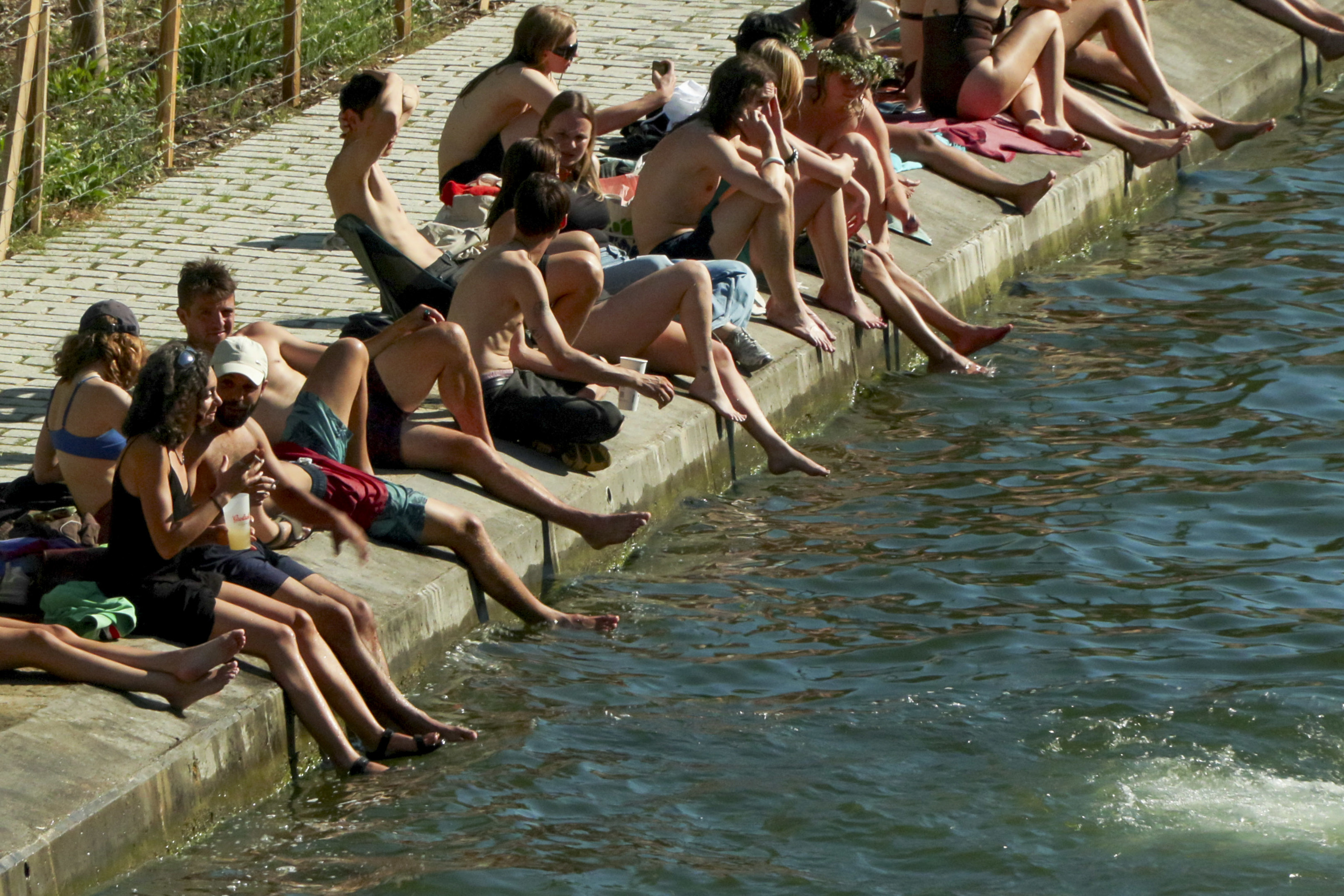 Ciudadanos se refrescan a orillas de un río en una localidad francesa