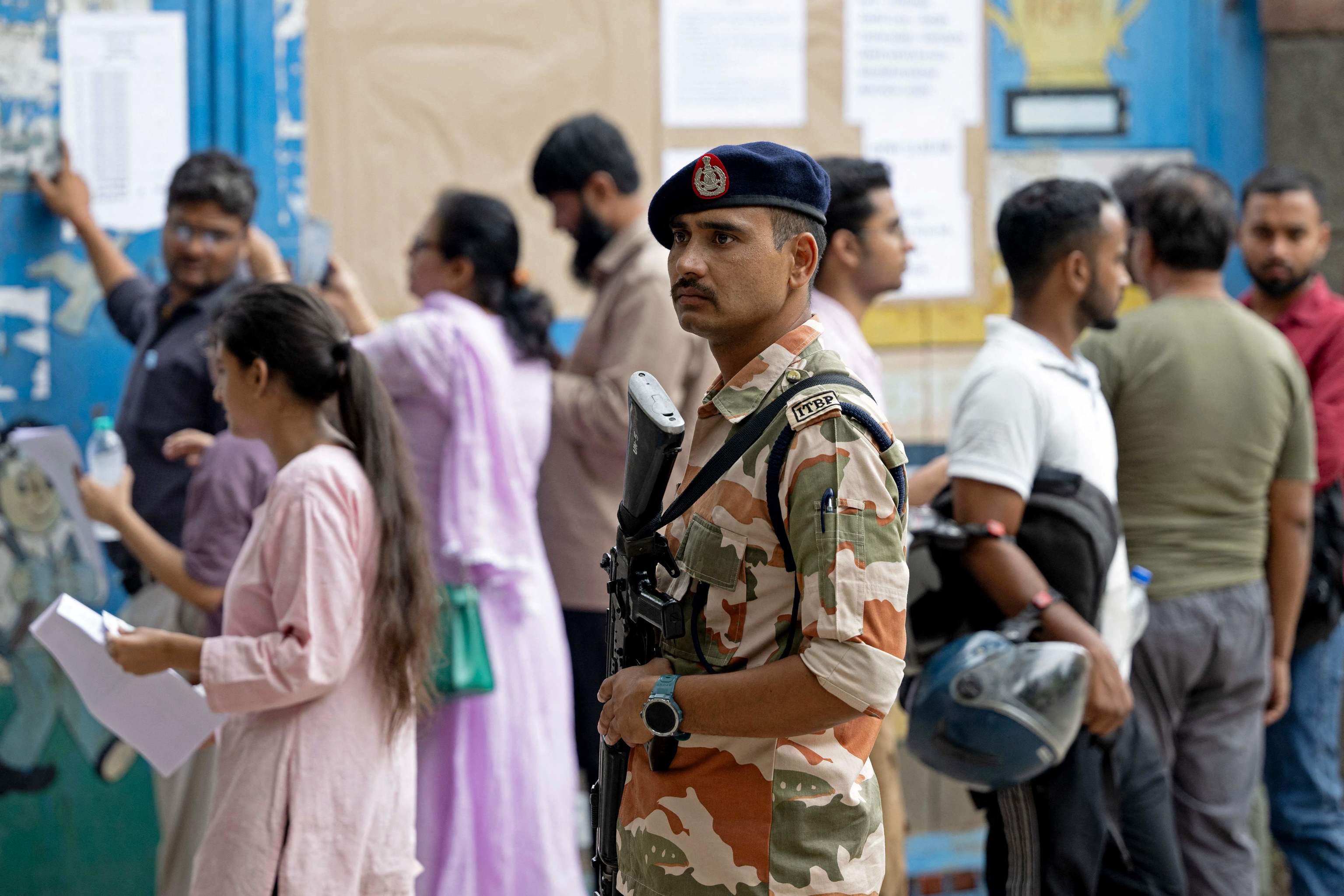 Personal de seguridad vigila la entrada a uno de los centros educativos en Nueva Delhi donde se celebran los exámenes