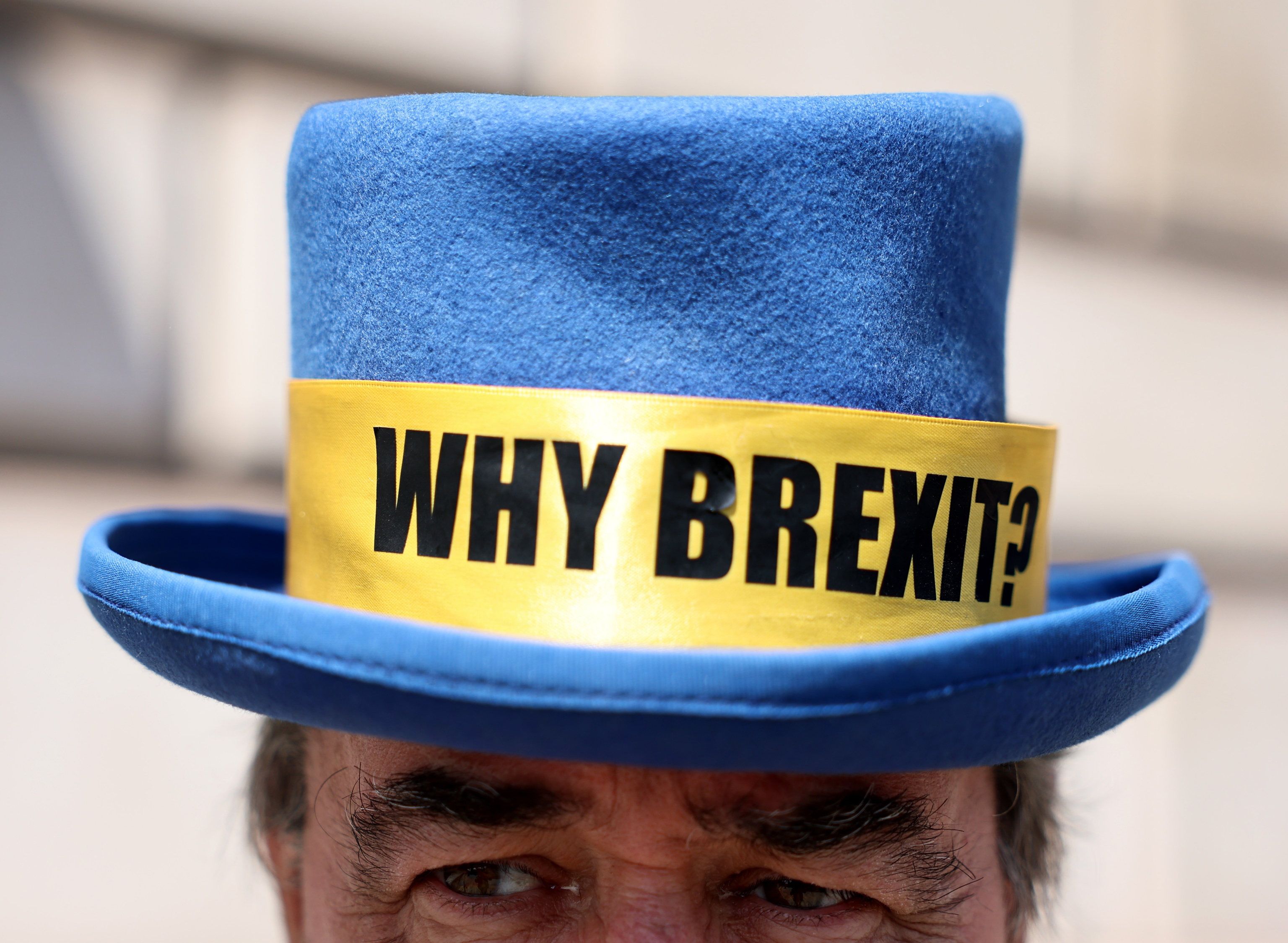 Un hombre luce un sombrero azul con la inscripción ¿Por qué Brexit?