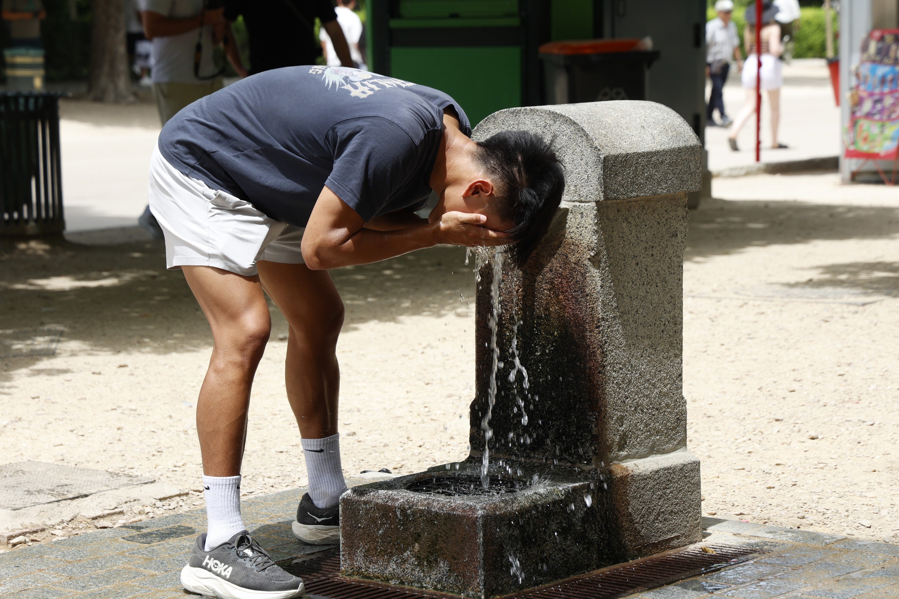Una persona se refresca con agua para soportar el calor.