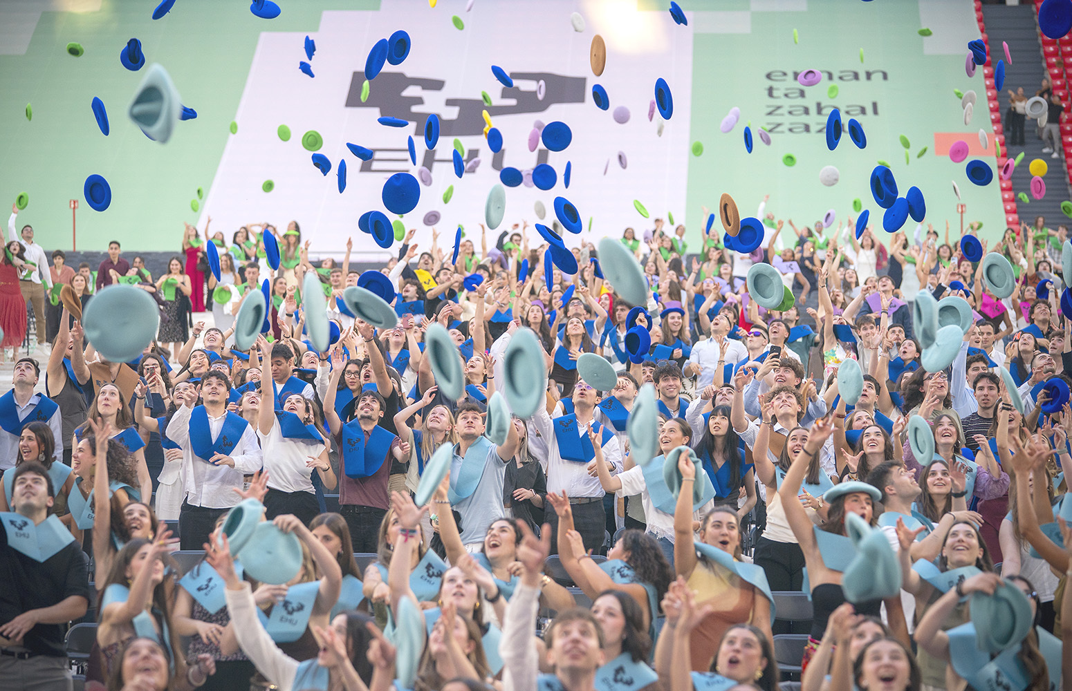 Alumnos de la Universidad vasca celebran su graduación lanzando al aire sus txapelas en el estadio de San Mamés.