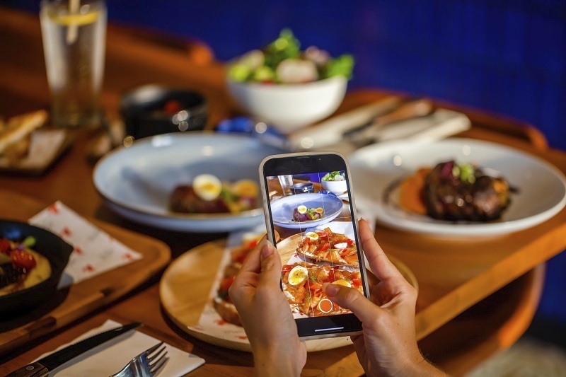 Una persona fotografía su comida para redes.