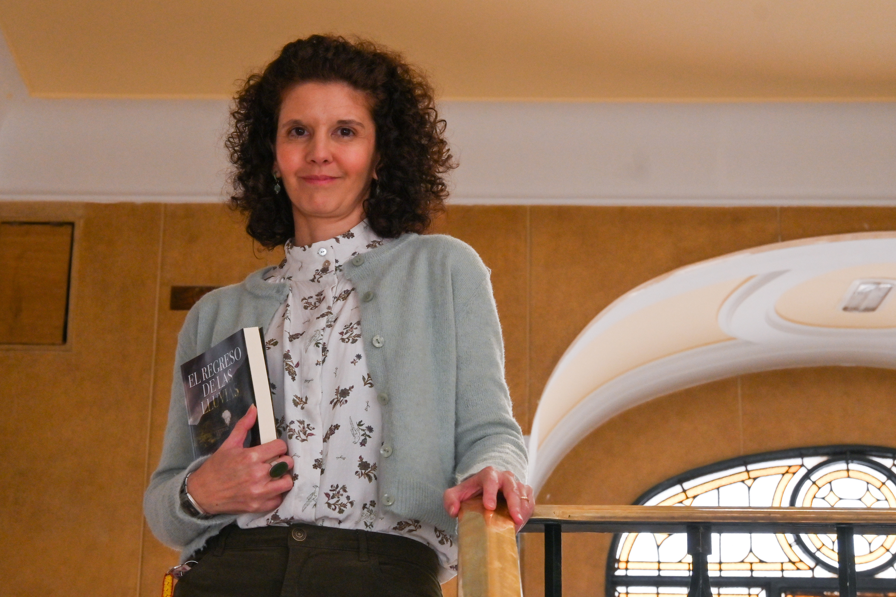 Beatriz Álvarez en las escaleras del edificio donde trabaja sosteniendo su primera novela.