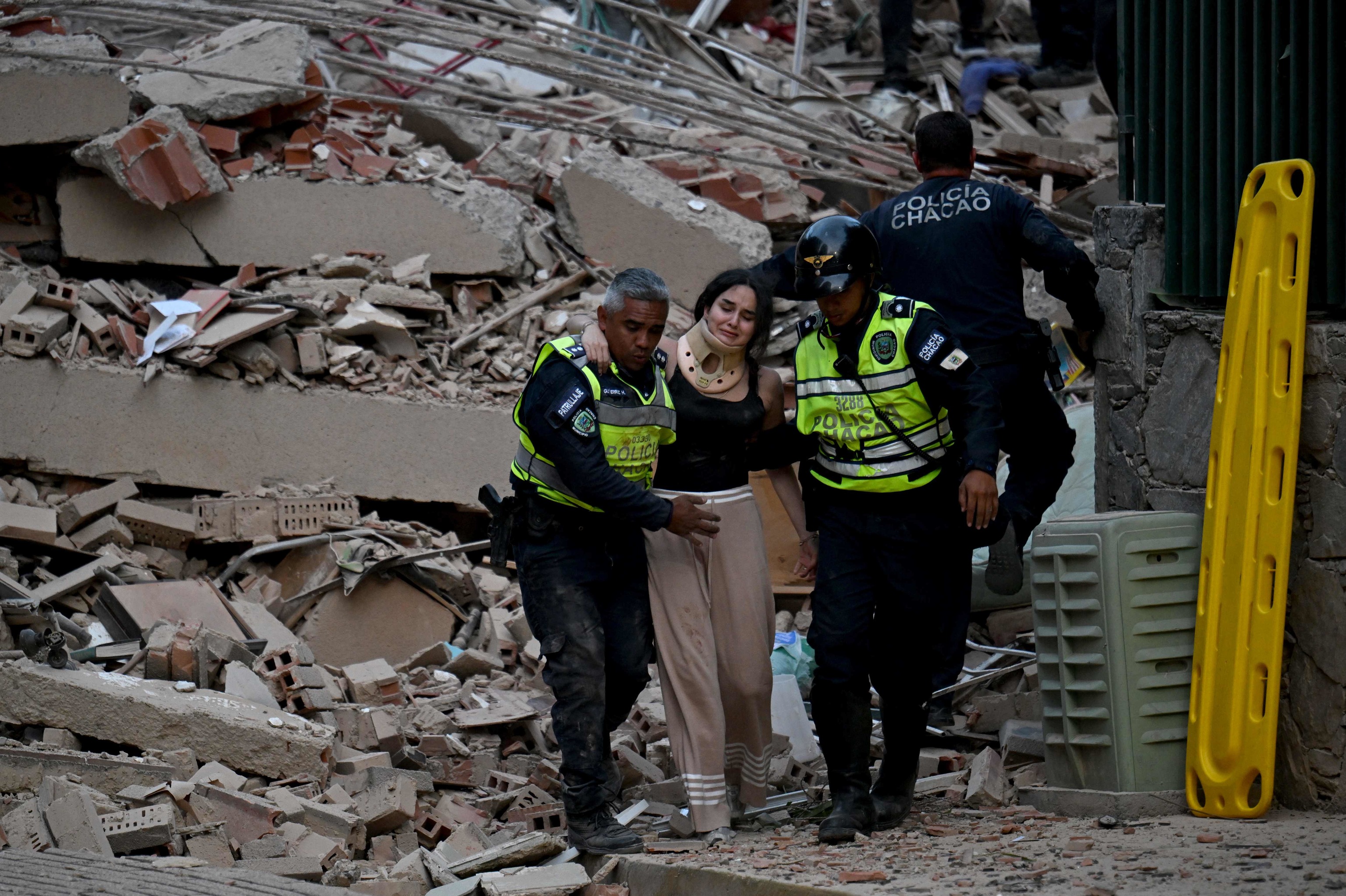 Equipos de emergencia ayudan a una persona a salir de los escombros de un edificio tras el terremoto.