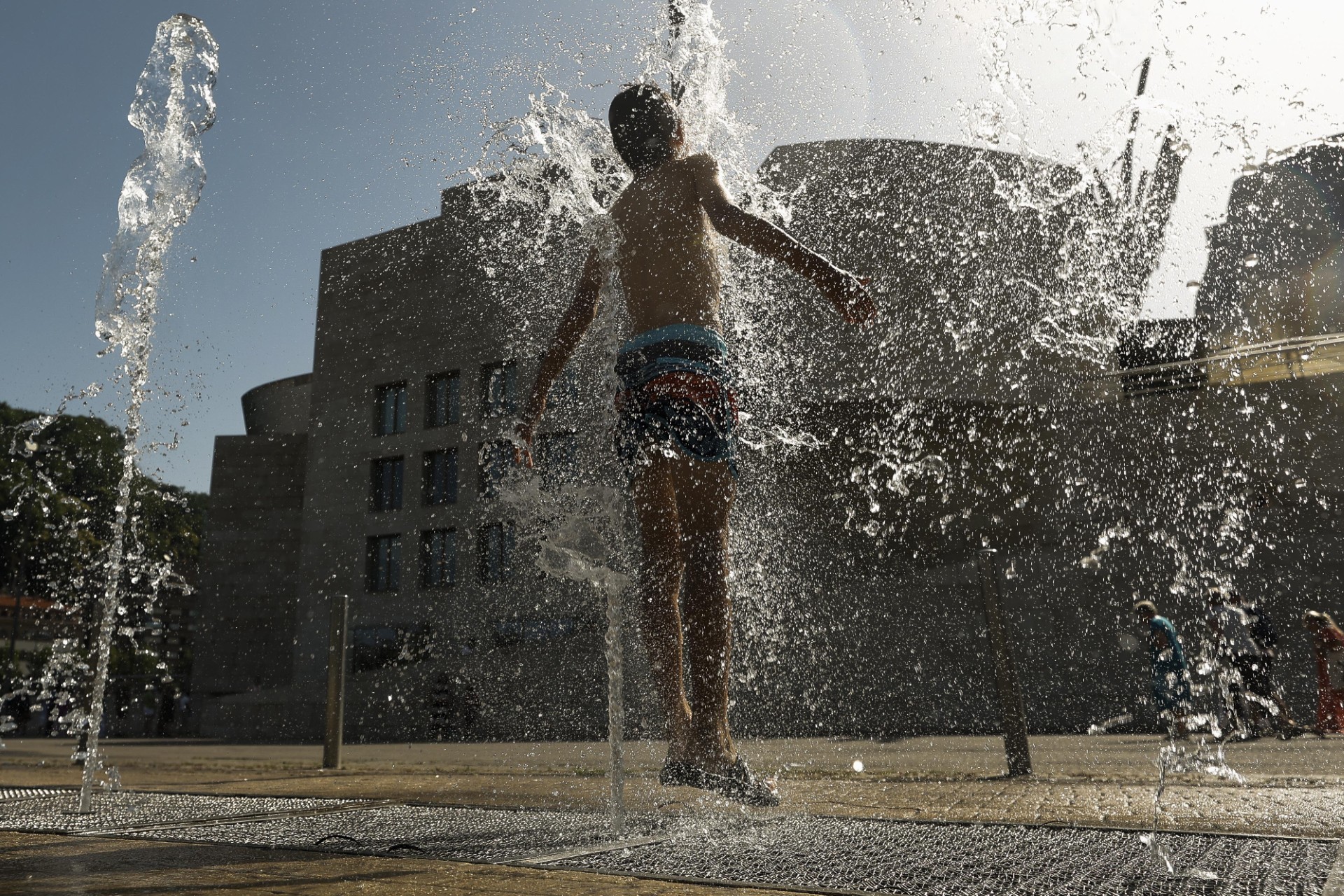 Un joven se refresca en una fuente frente al Museo Guggenheim el martes, cuando se registraron 40 grados en Bilbao.
