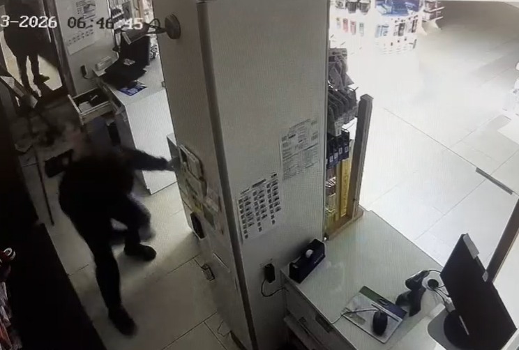Uno de los ladrones tras entrar en una farmacia de madrugada para robar