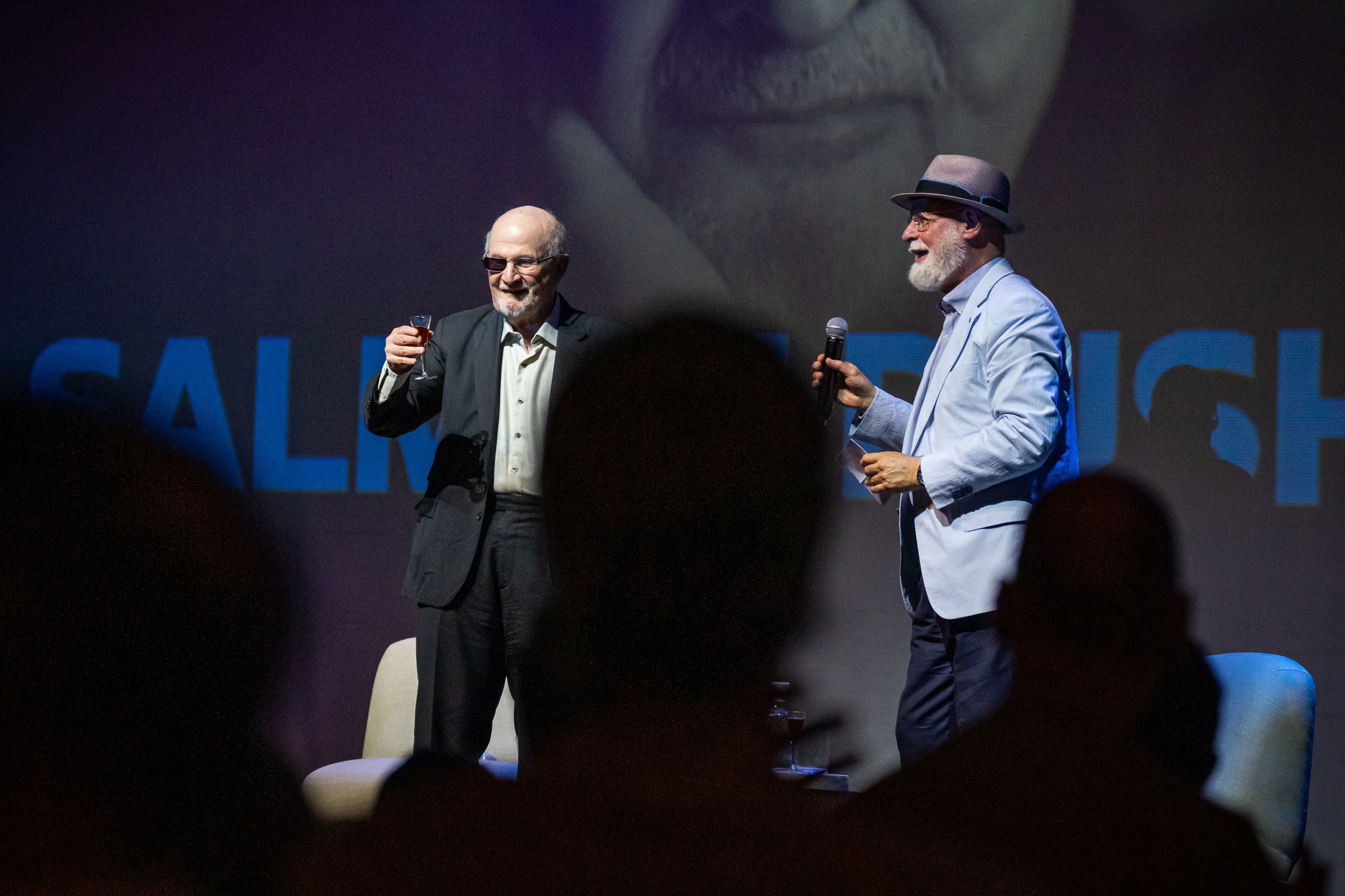 Rushdie, acompañado por Alberto Manguel, brindando con el público portuense.