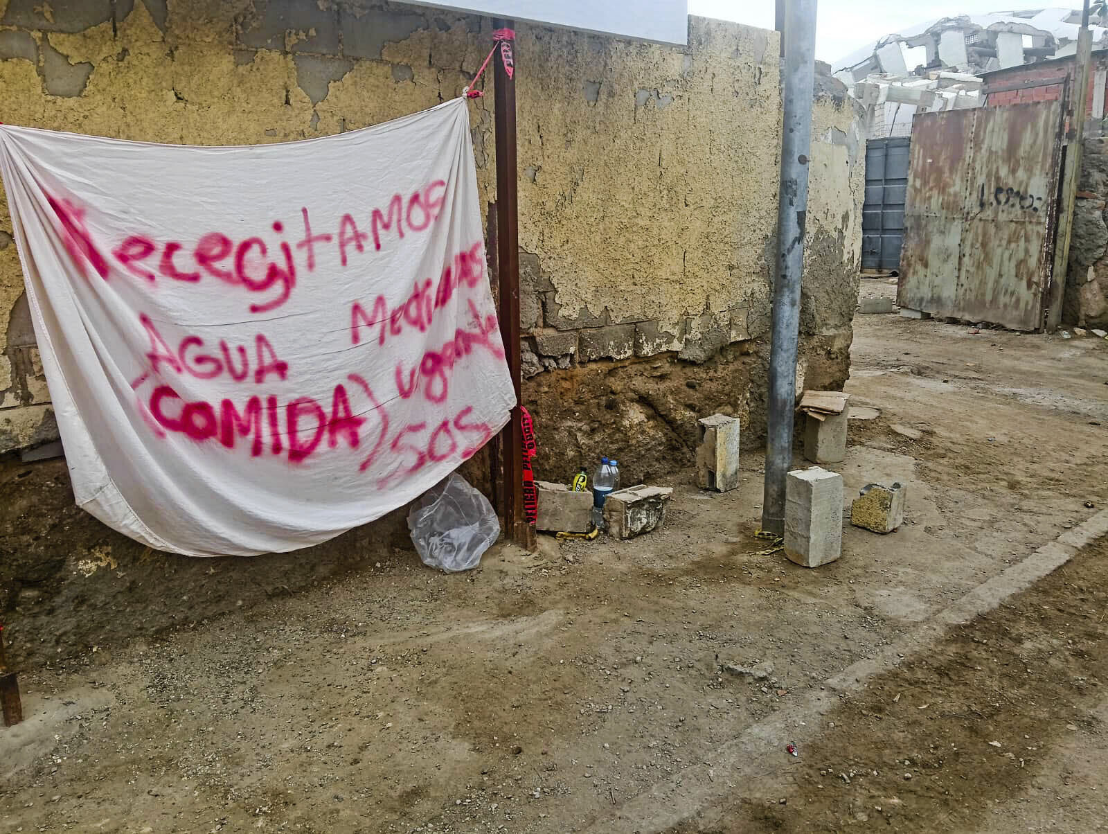 Una sábana con un rótulo pintado pidiendo ayuda.