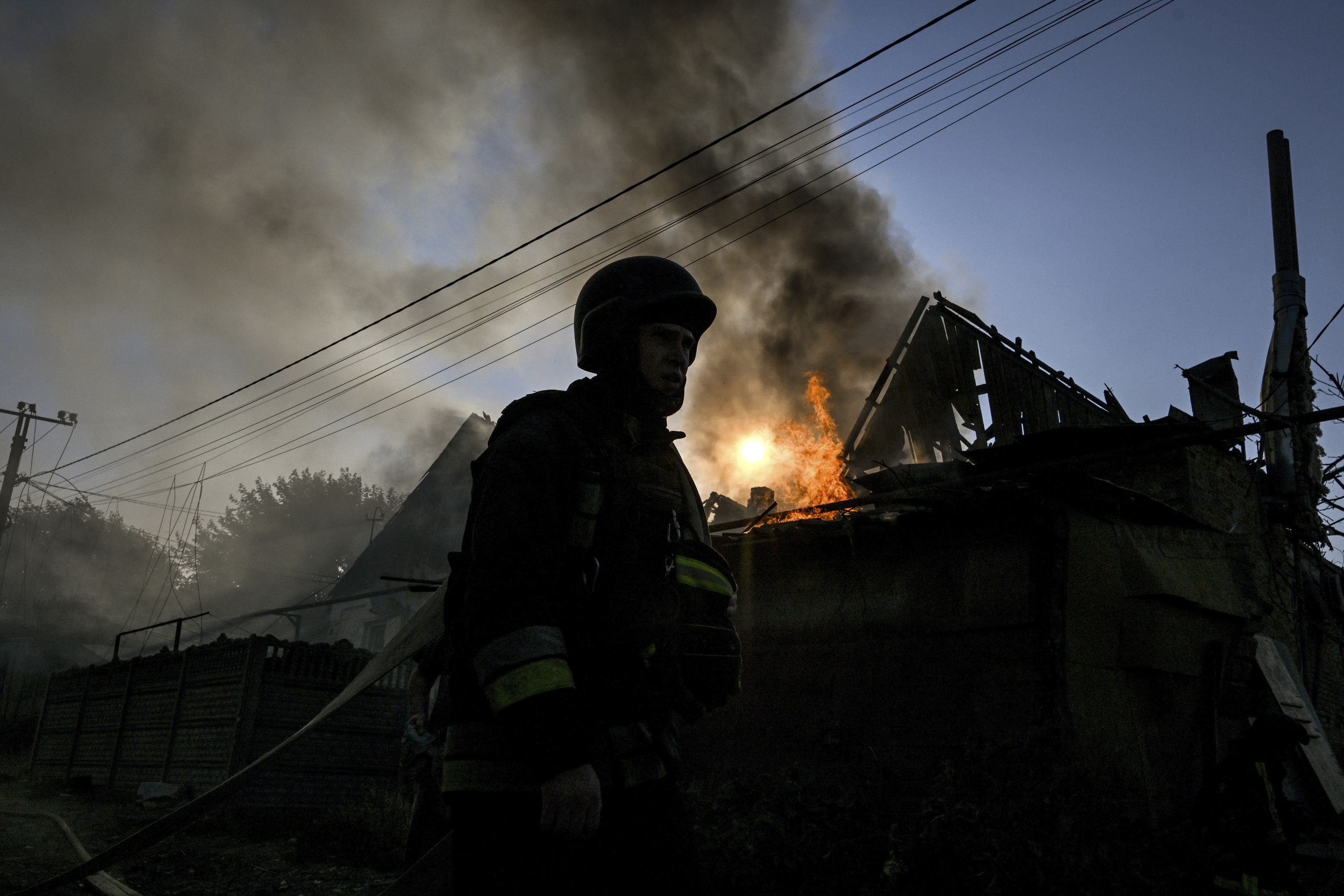 Un rescatista del Servicio Estatal de Emergencias frente a una casa destruida en Zaporiyia.