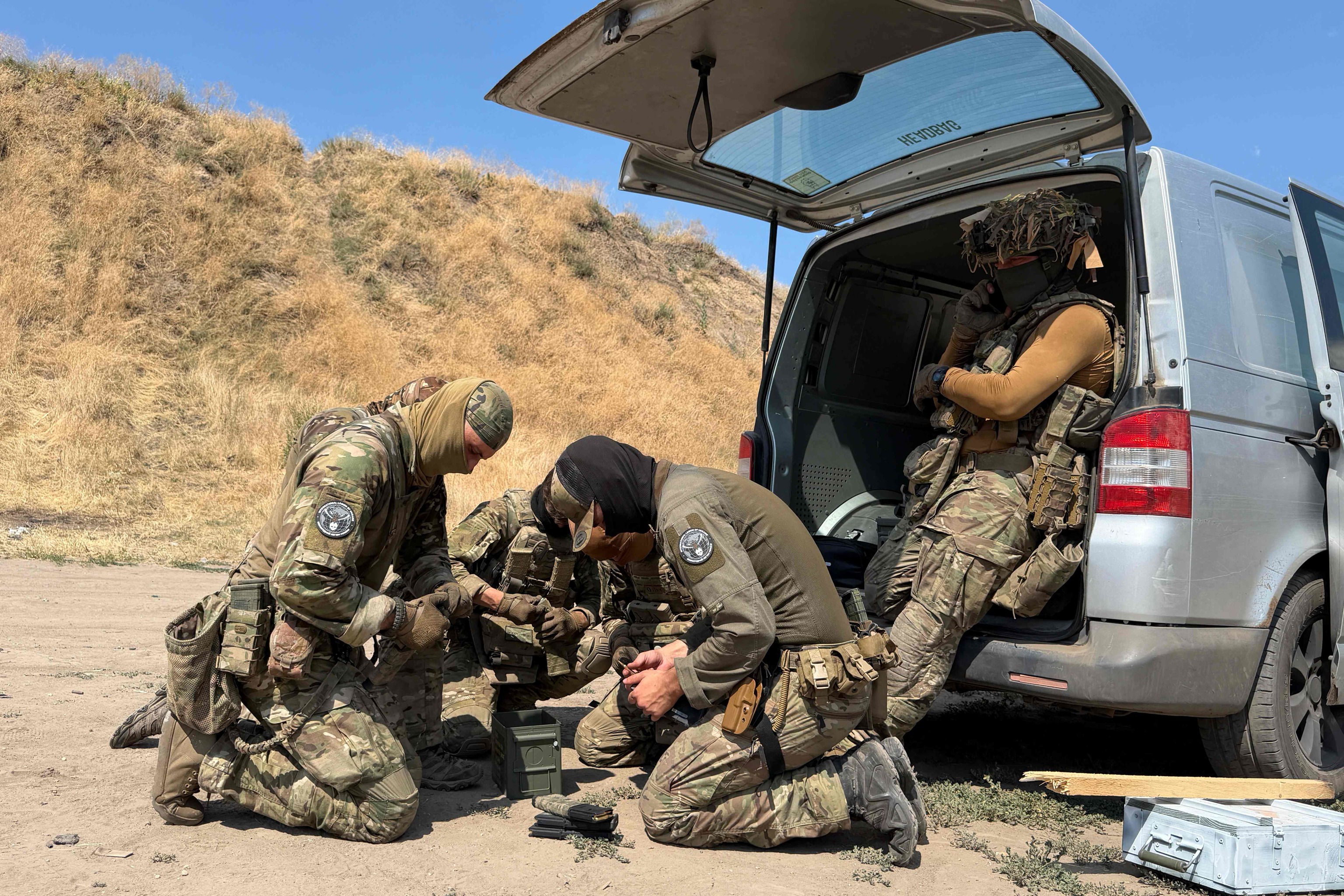 Un grupo de voluntarios franceses del Grupo Táctico Revanche cargan cargadores de fusil, en Zaporiyia.