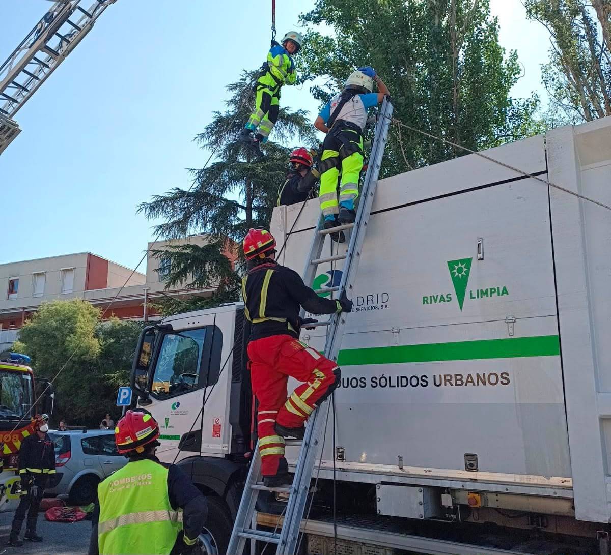 Operario del Suma y bombero rescatando a la mujer del camión de reciclaje