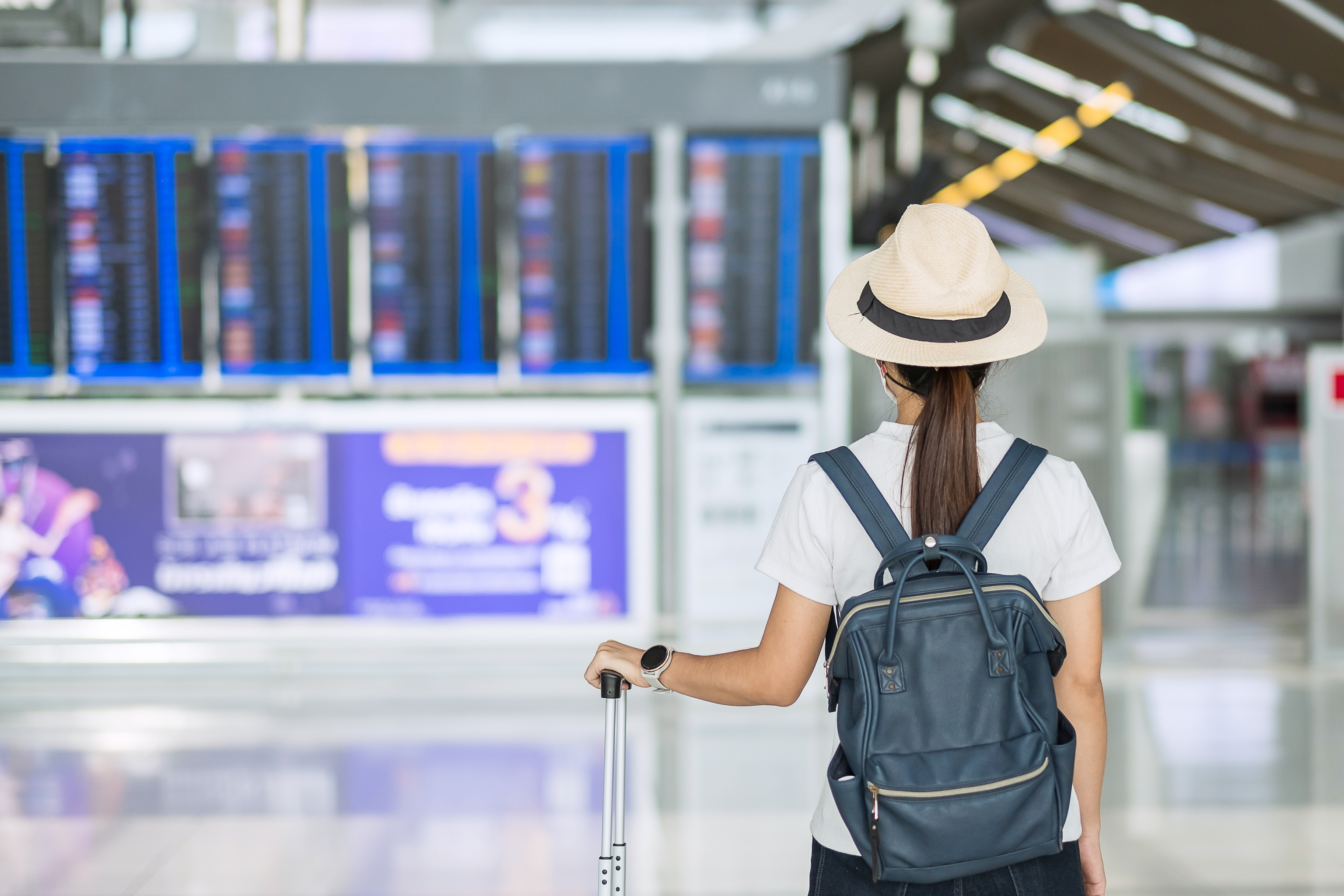 Una mujer contempla las pantallas de un aeropuerto.