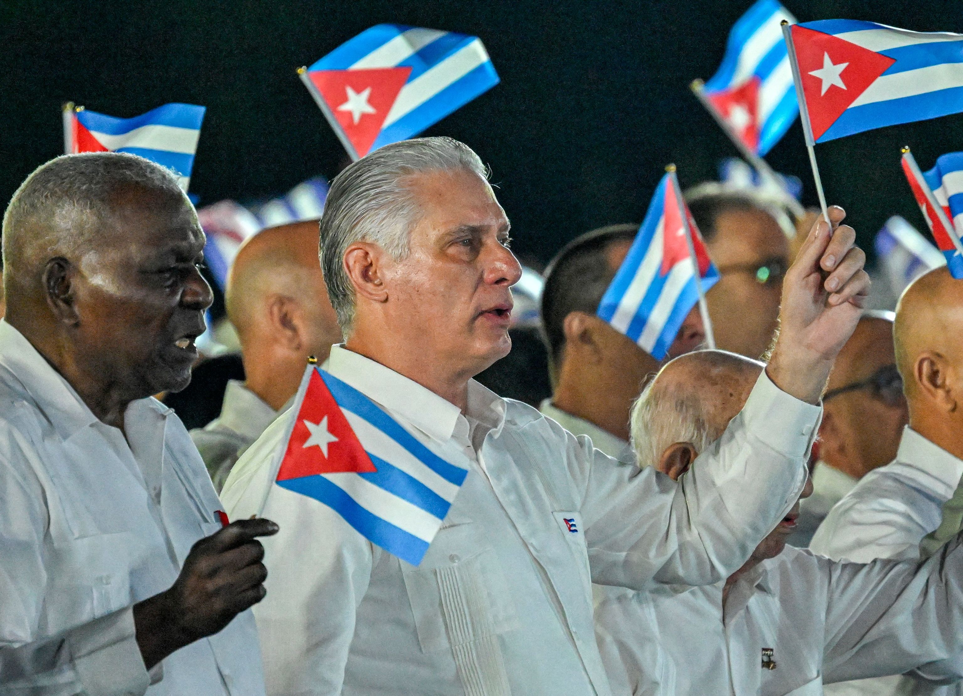 El presidente cubano, Miguel Díaz-Canel, agita banderas del país durante el 73.º aniversario del asalto al Cuartel Moncada, este domingo.