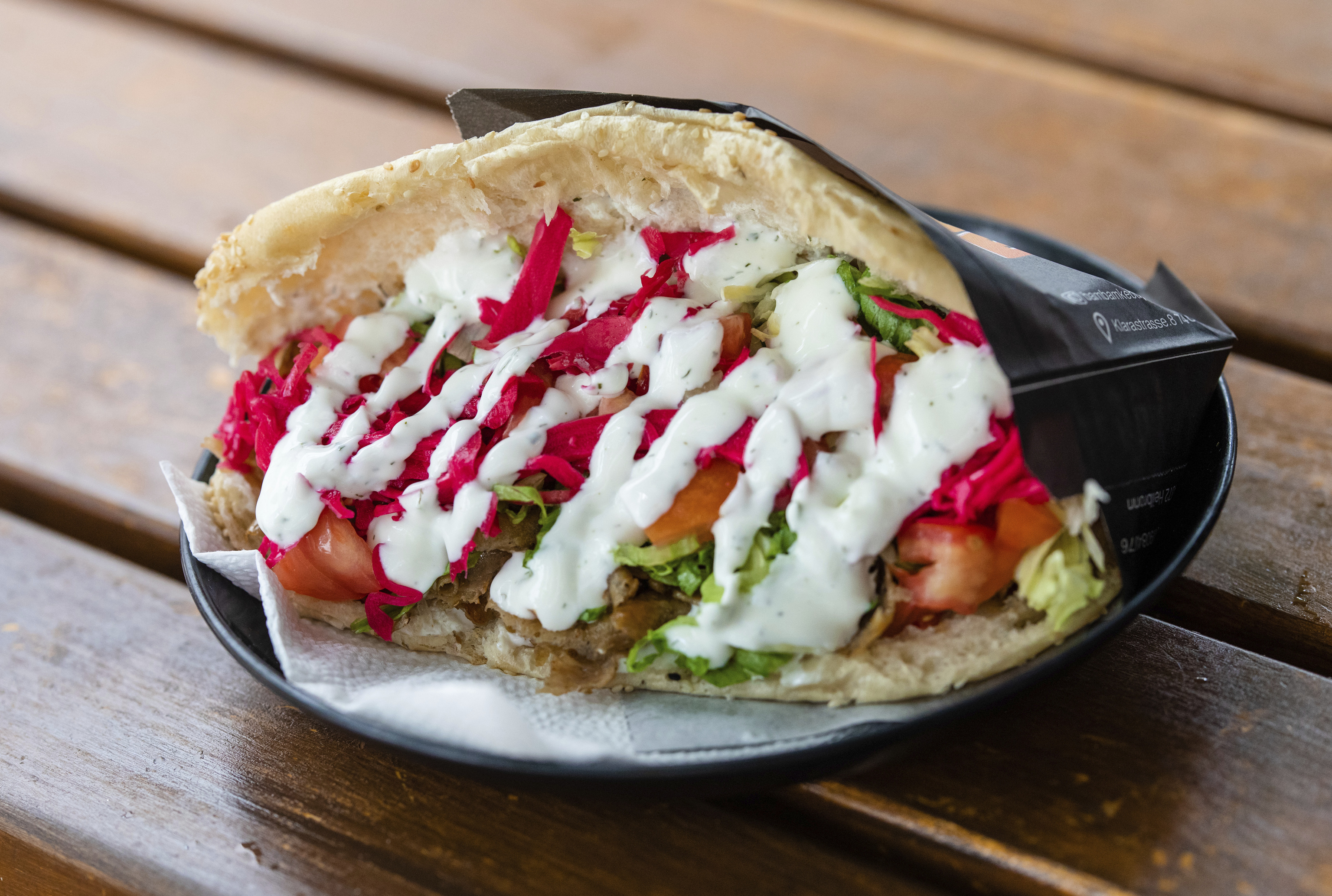 Un kebab relleno de salsas y varios ingredientes en un establecimiento alemán.
