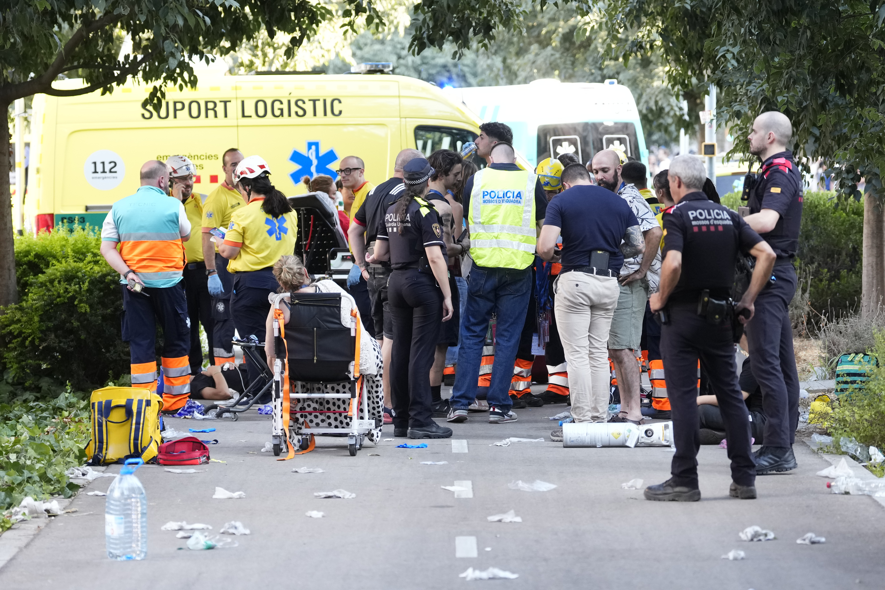 Agentes de los Mossos y de Emergencias junto a un grupo de afectados en los exteriores del Clot
